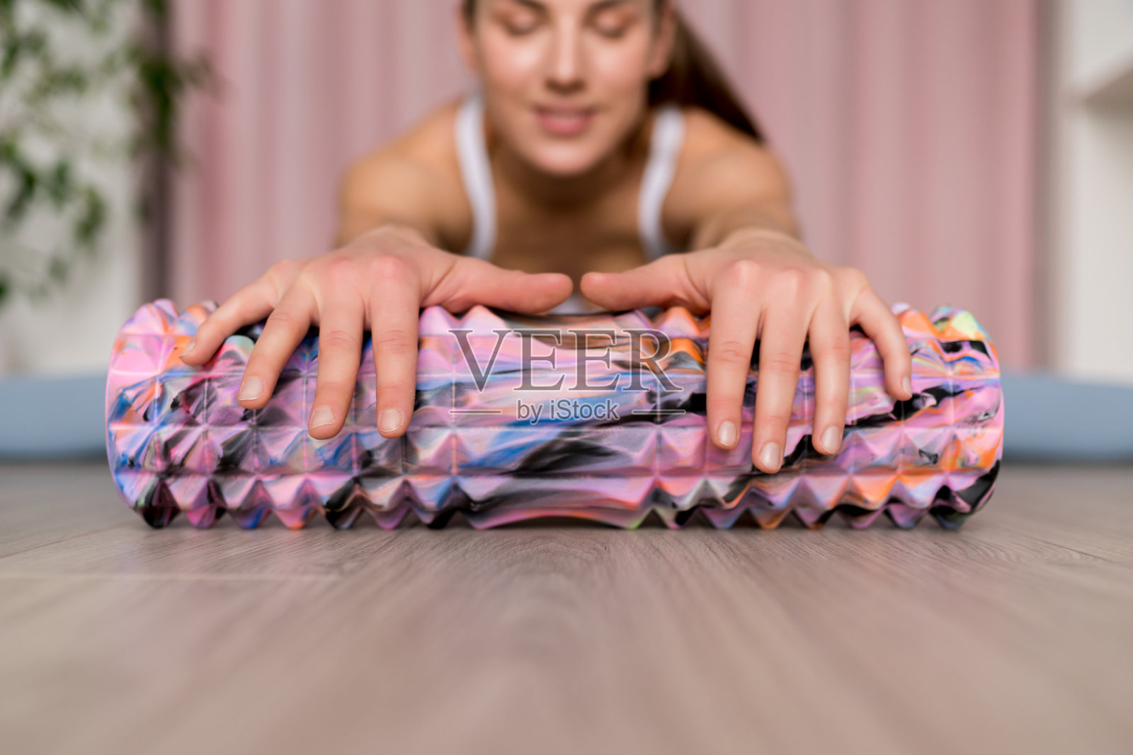 紧密的强泡沫辊。高密度深层组织按摩器，用于肌肉按摩和肌筋膜触发点释放。积极的生活方式，锻炼，健身理念照片摄影图片