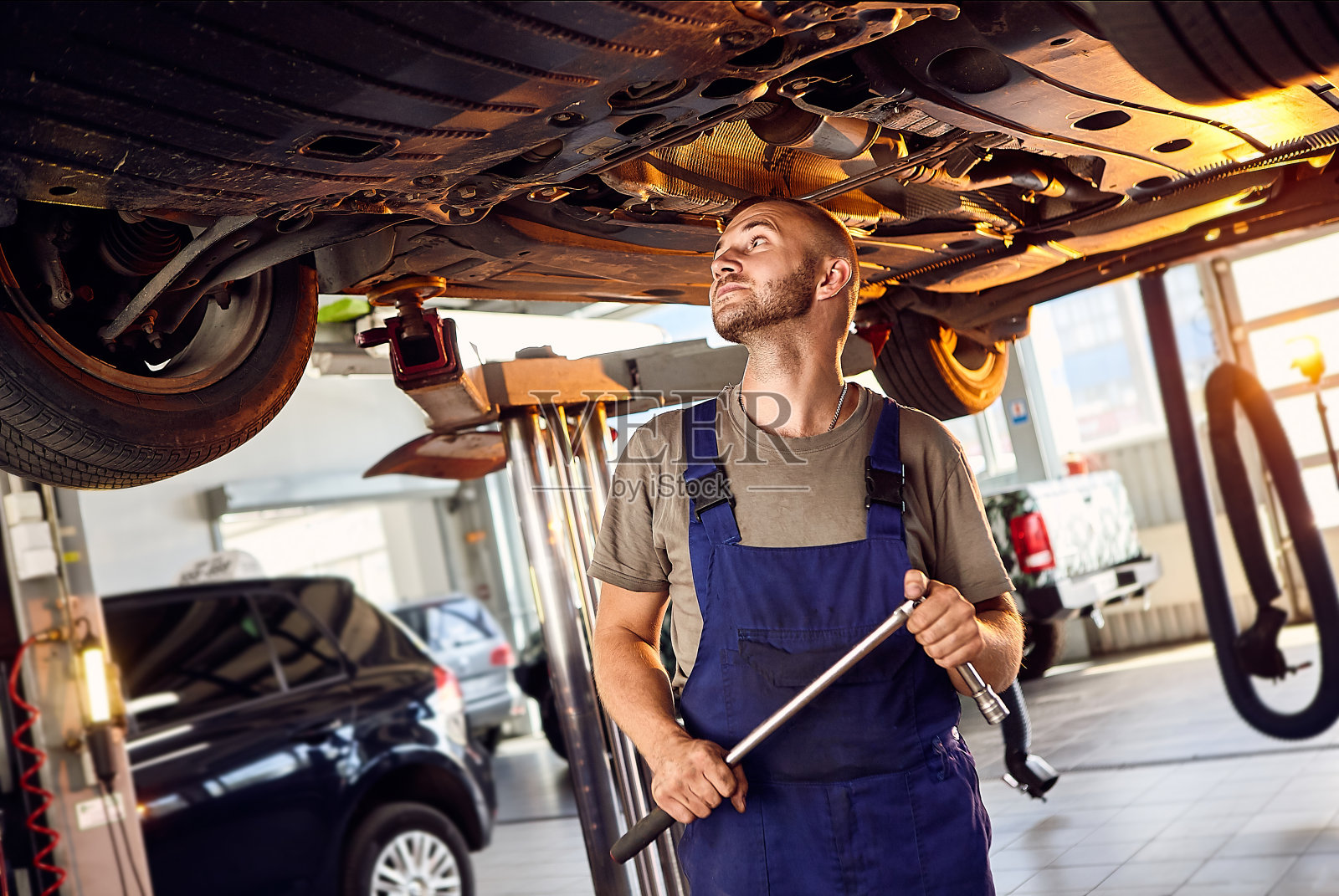 汽车机械师在维修站对汽车运行机构进行检查。男工人修理汽车。车辆维修的概念照片摄影图片
