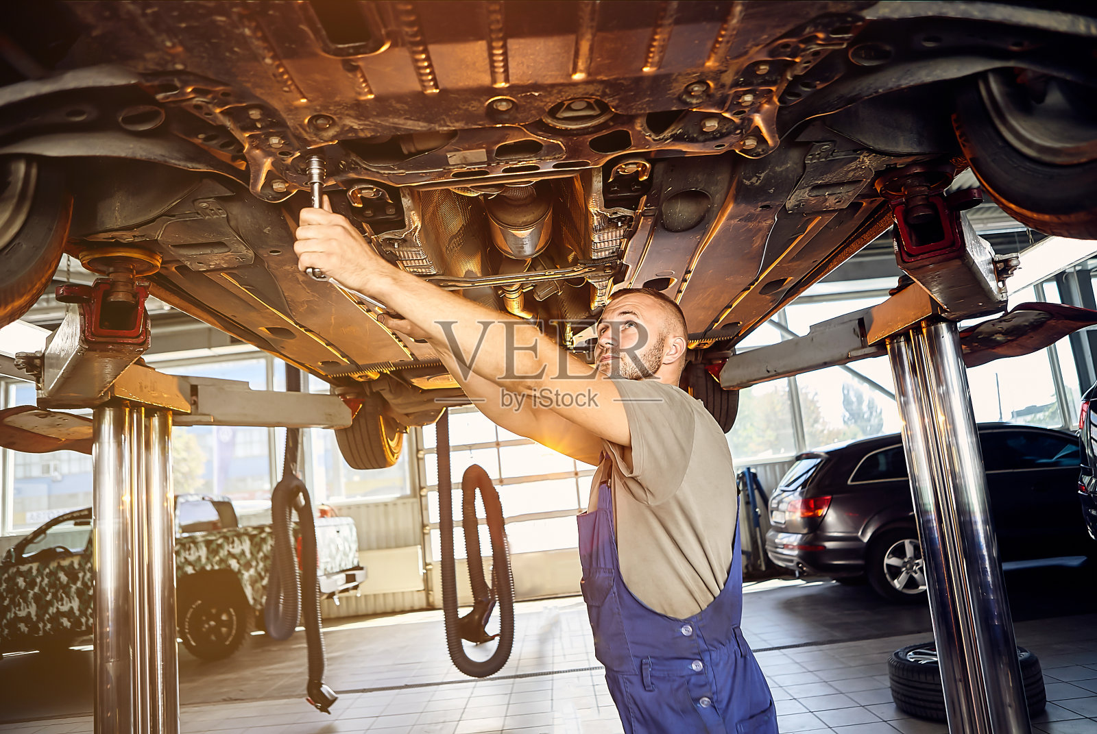 汽车机械师在维修站对汽车运行机构进行检查。男工人修理汽车。车辆维修的概念照片摄影图片