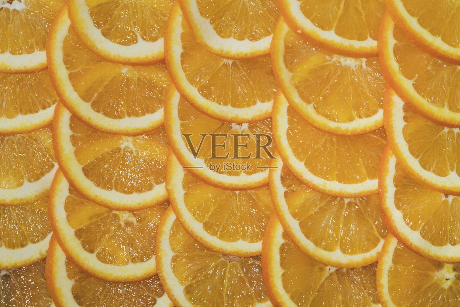 桌上放着一个切成片的橘子。照片摄影图片