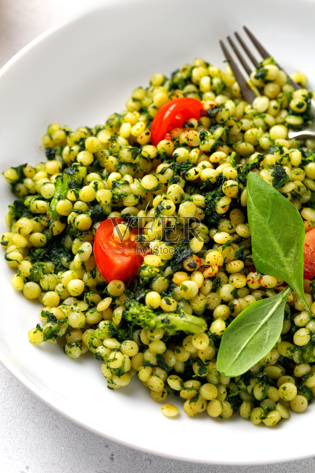 配菠菜和西兰花的以色列古斯米面照片摄影图片