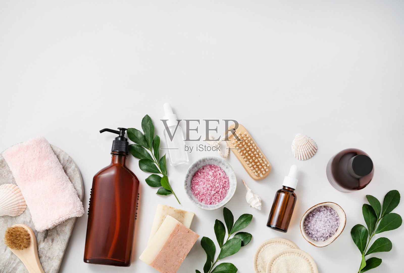 概念平躺的面部和身体护理化妆品与海盐，肥皂，海绵，刷子，乳液，贝壳，奶油在白色背景。俯视图和复制空间照片摄影图片