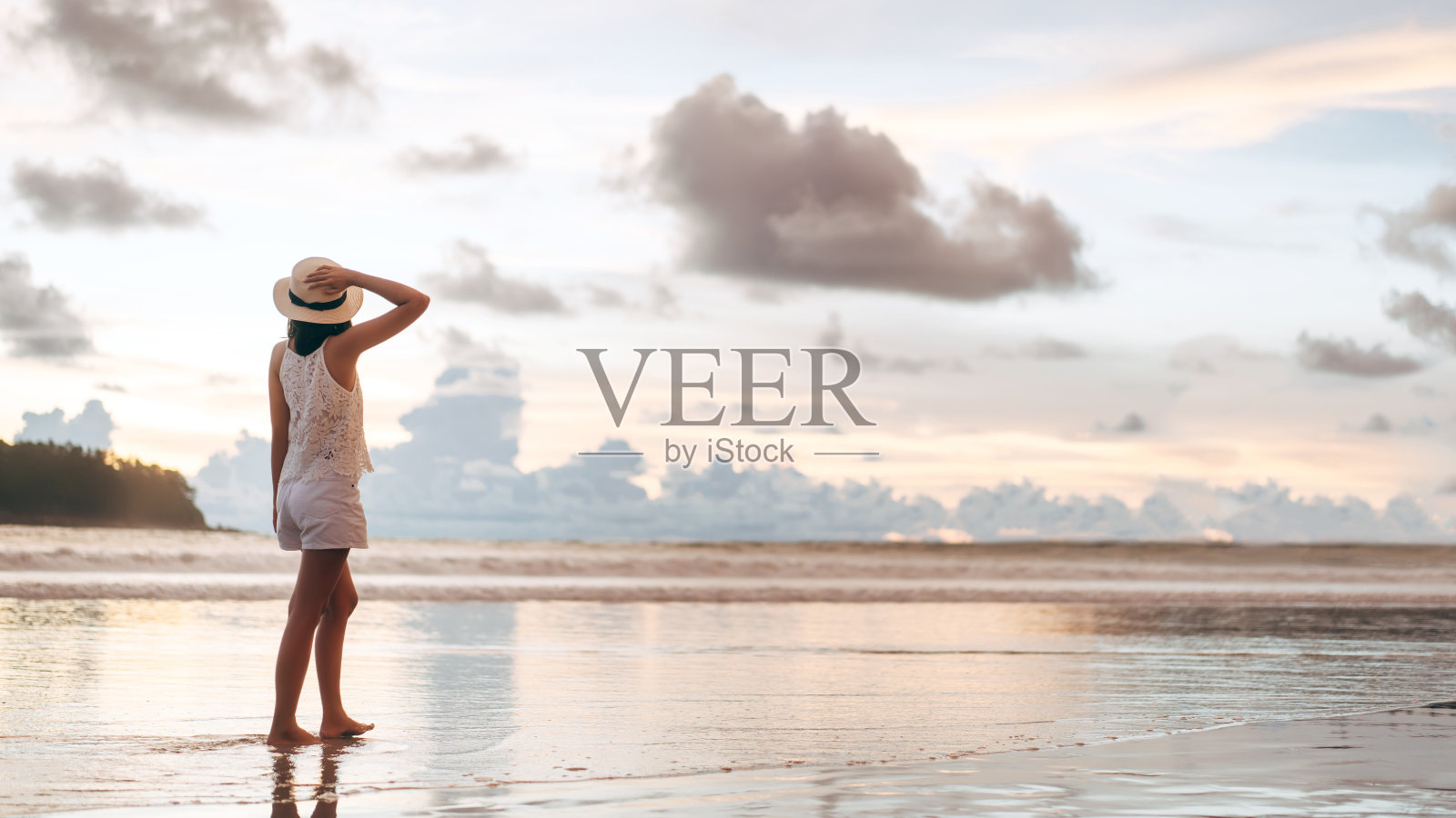 后视图年轻的成年游客亚洲妇女散步放松在沙滩上美丽的戏剧性日落天空照片摄影图片