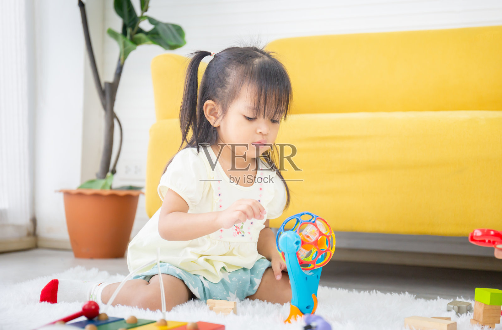 快乐的亚洲孩子在客厅玩耍的肖像，小女孩玩玩具的特写照片摄影图片