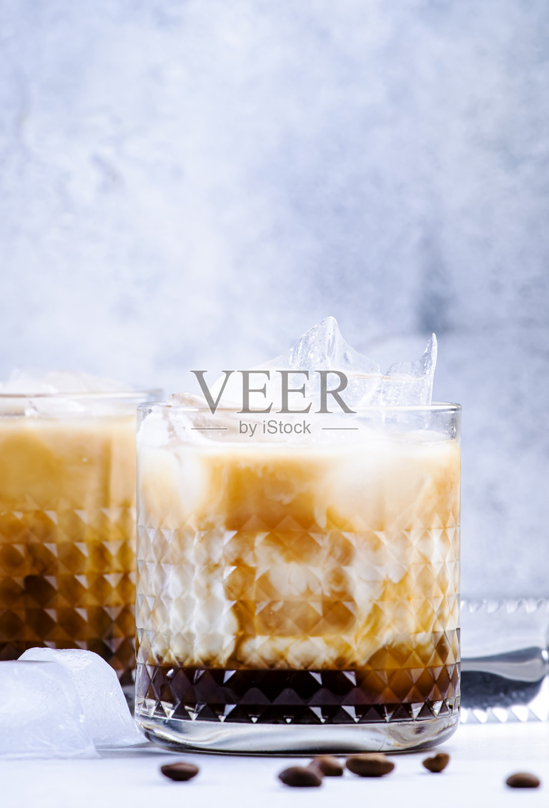 时髦的酒精鸡尾酒，伏特加，咖啡利口酒，奶油和冰，灰色背景，酒吧工具照片摄影图片