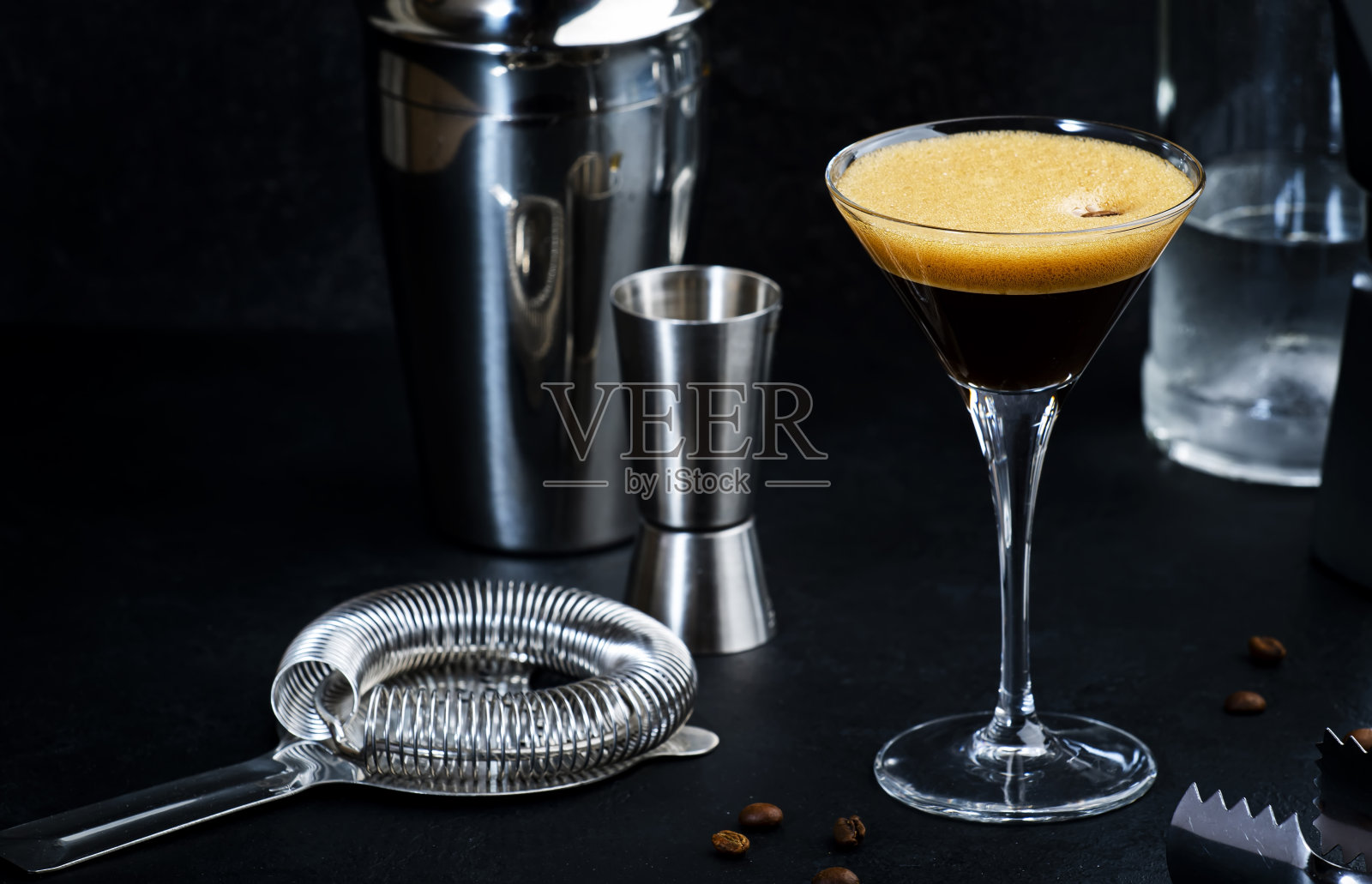 经典酒精鸡尾酒浓缩马提尼与伏特加，咖啡利口酒，糖浆和冰在黑暗的柜台背景，酒吧工具，负空间照片摄影图片