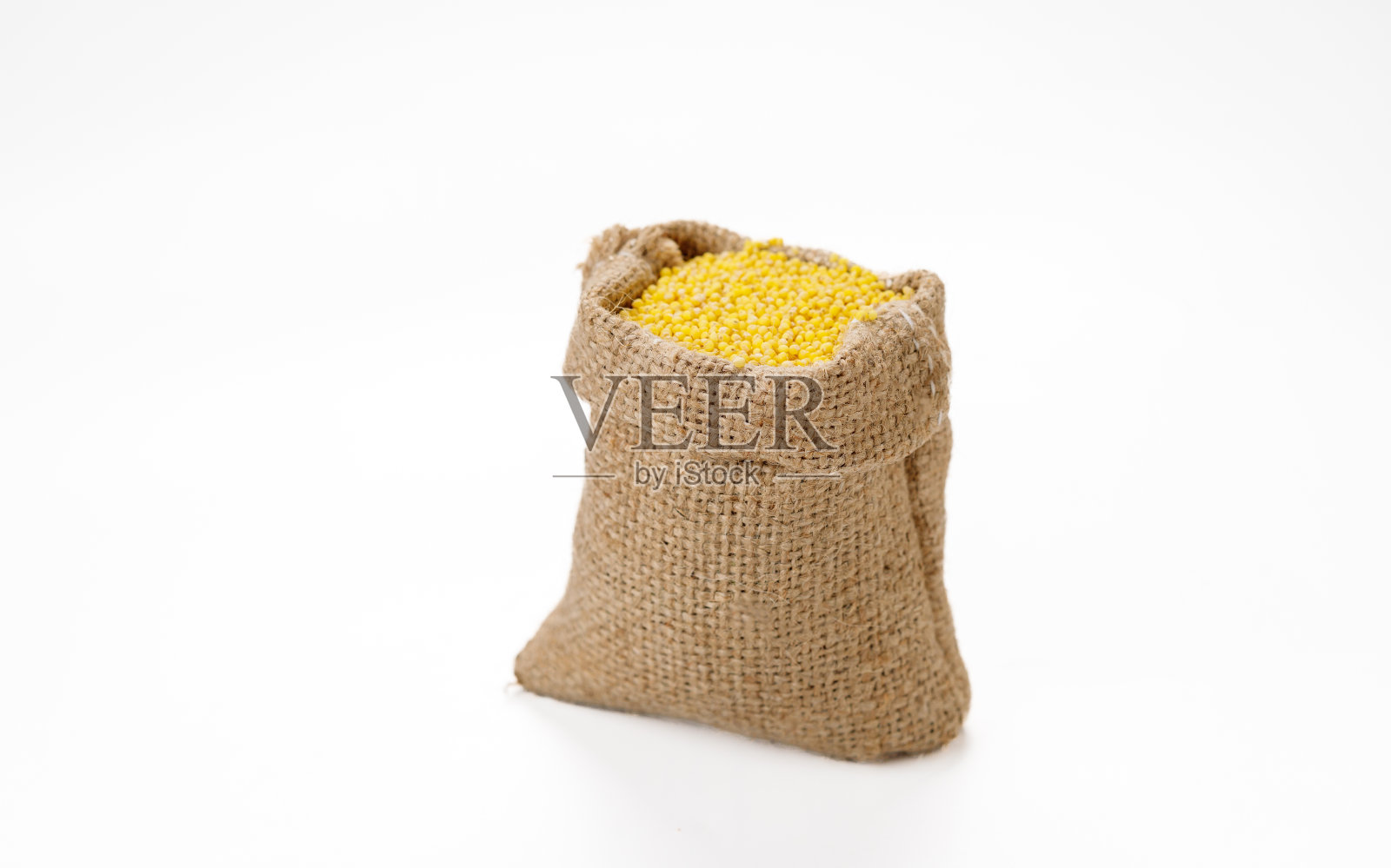 在白色的背景上，用碗和袋子擦亮小米。高质量的照片照片摄影图片