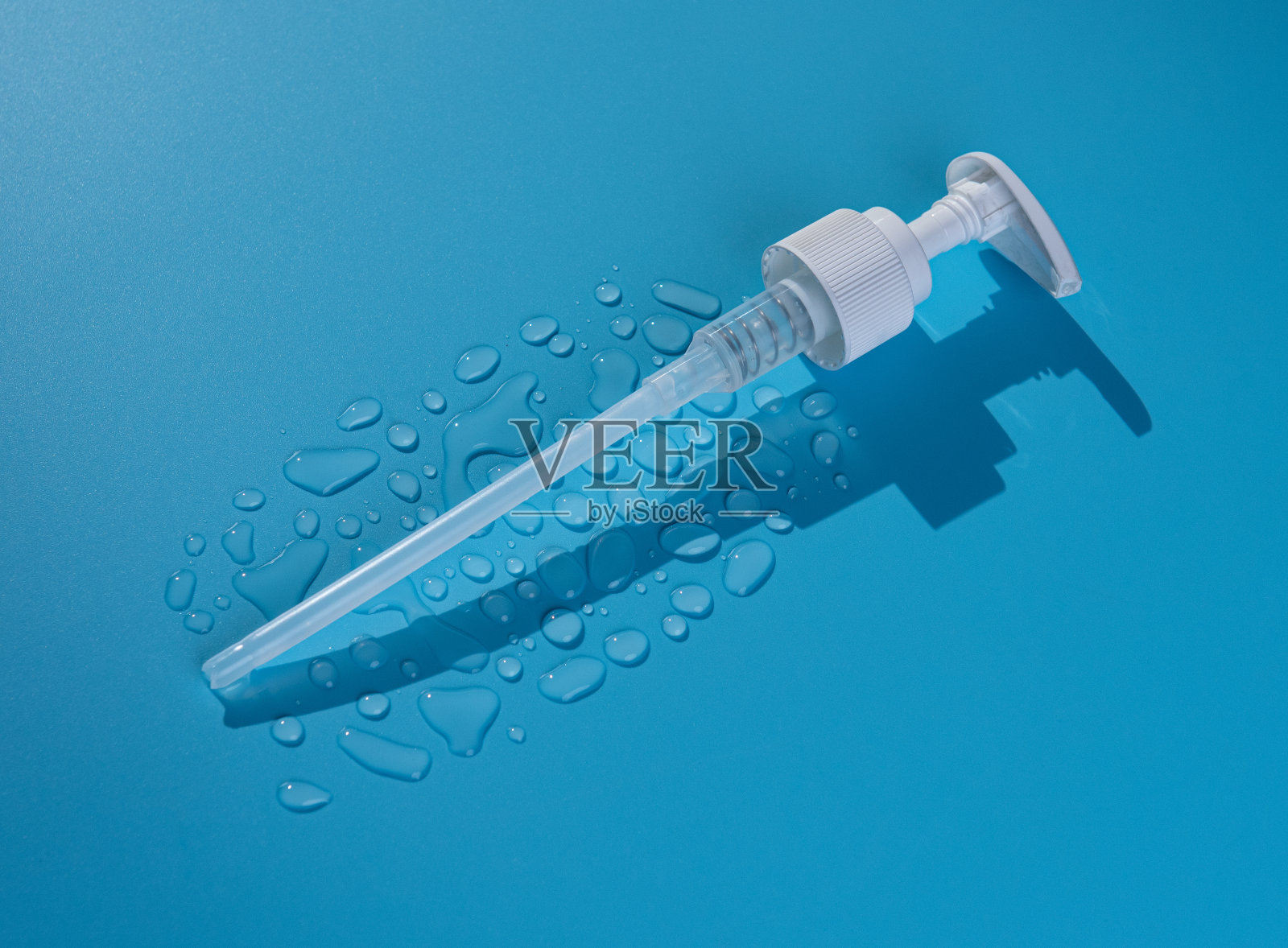 分配器无空气泵和滴胶液体，滴洗剂，和其他化妆品蓝色背景照片摄影图片