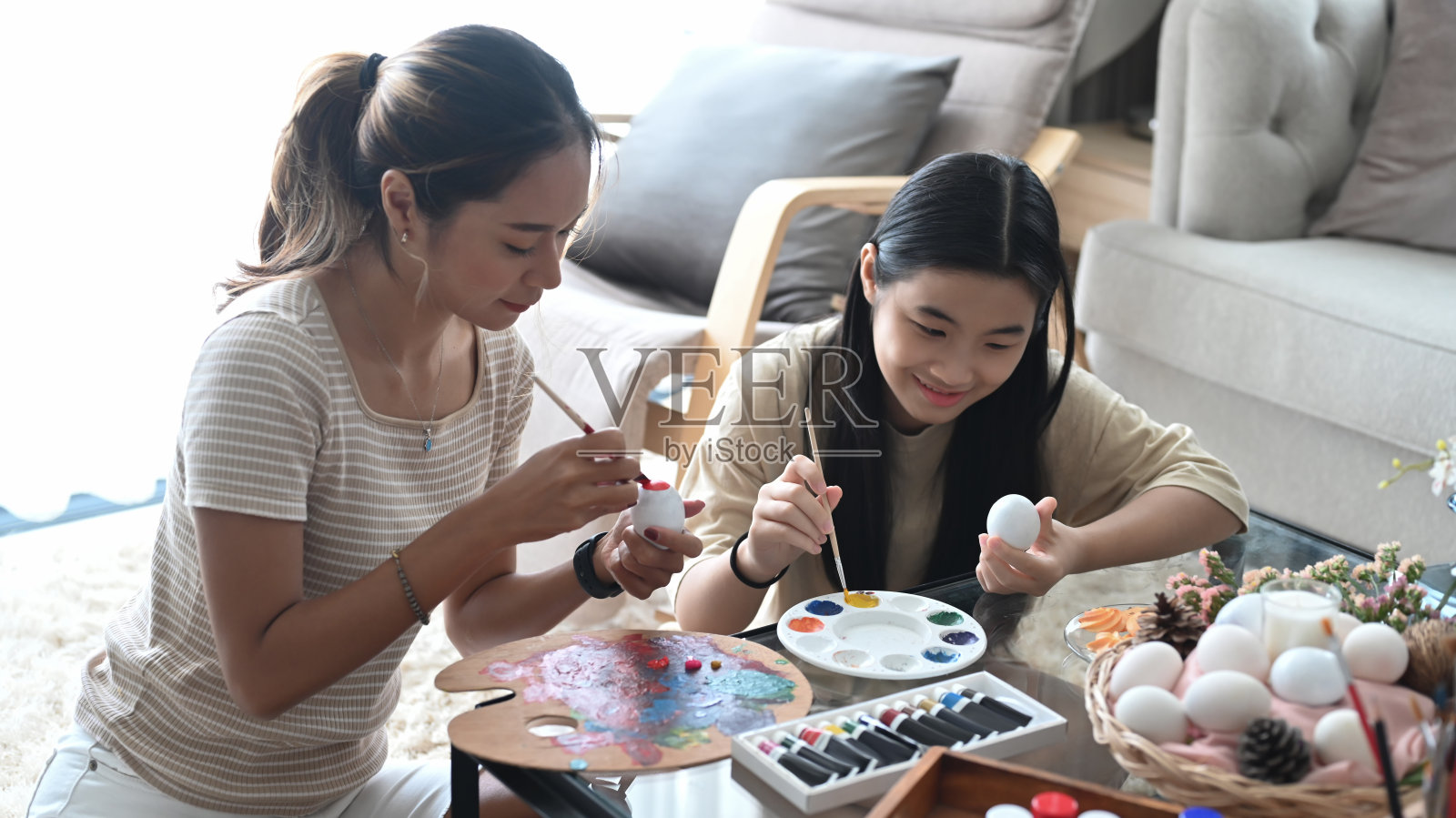 母亲和女儿准备复活节庆祝活动，并在家中共度闲暇时光。照片摄影图片