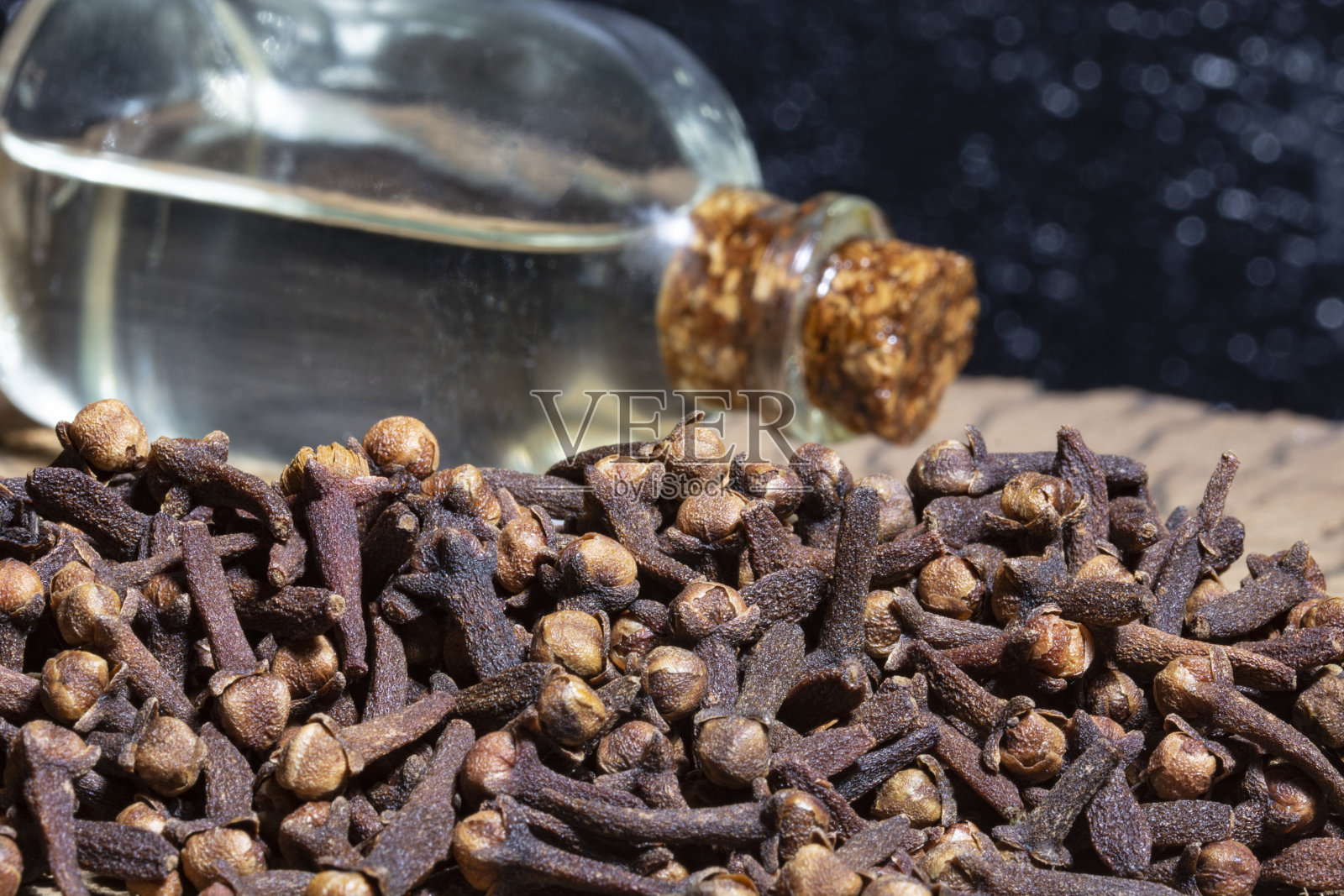 丁香籽和油在黑色的背景上照片摄影图片