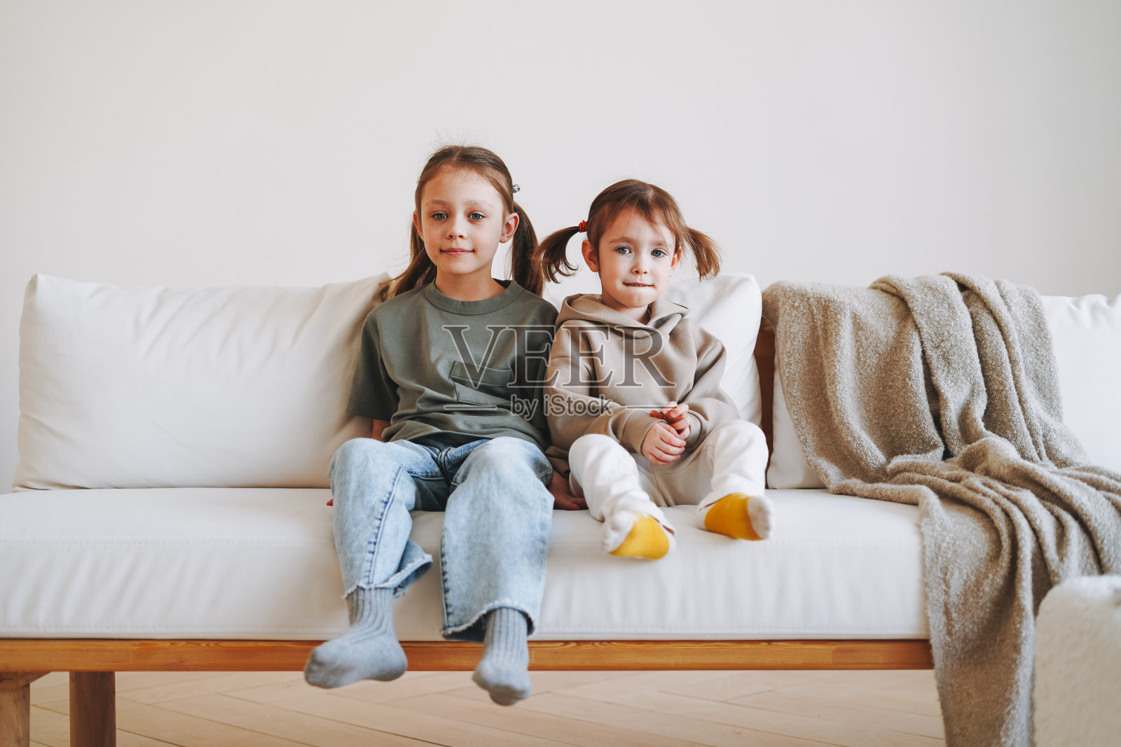 治愈两个孩子，女孩姐妹在家里的沙发上玩照片摄影图片
