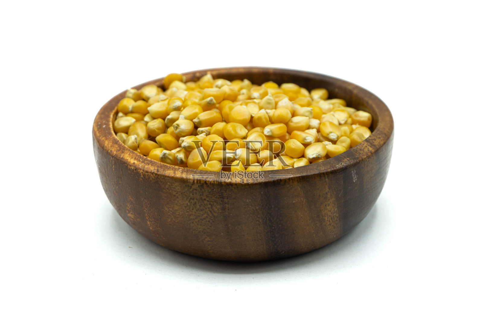 白色背景中装在木碗里的玉米粒照片摄影图片