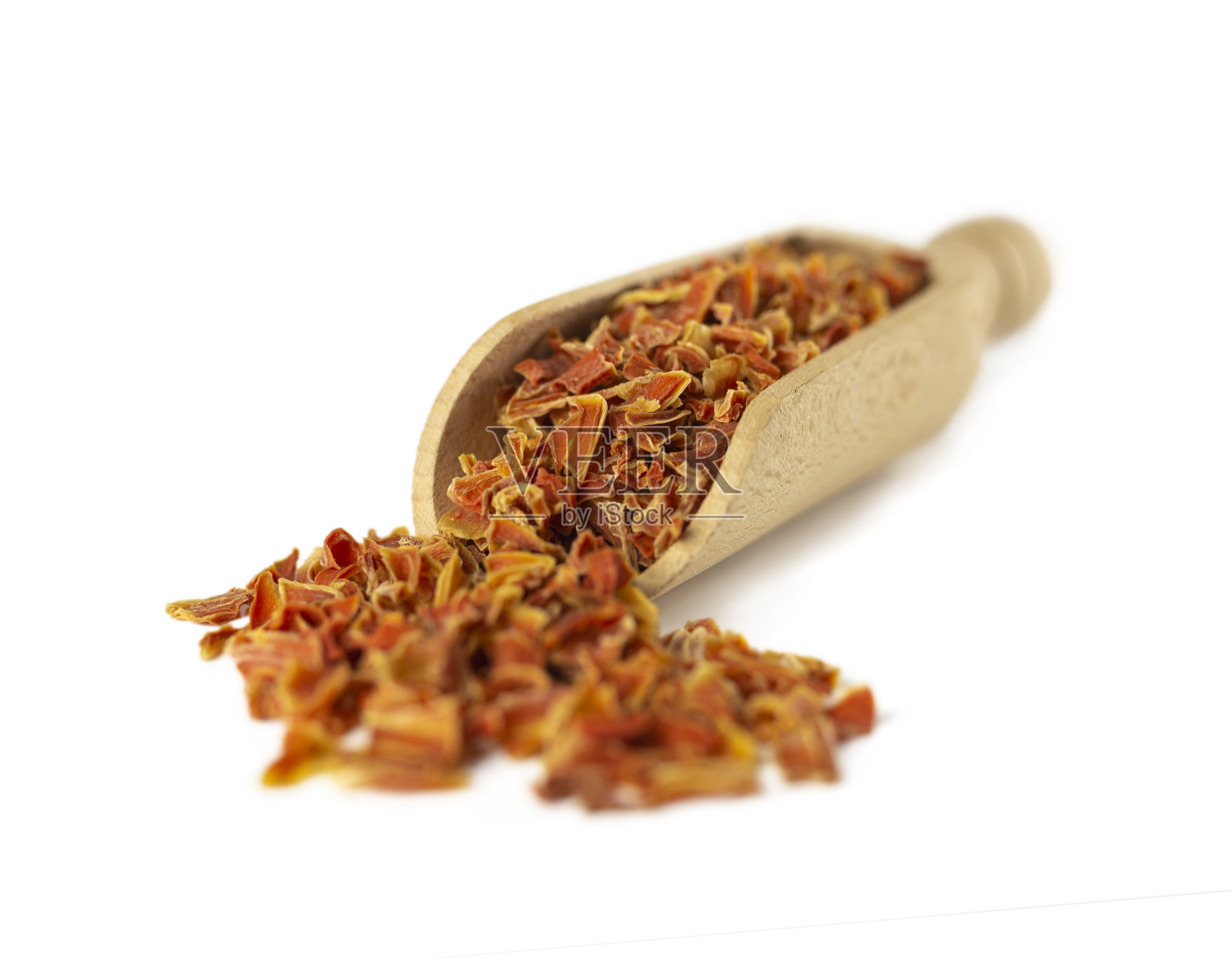 干胡萝卜片在木勺孤立在白色背景。香料和食物配料。浅景深。照片摄影图片