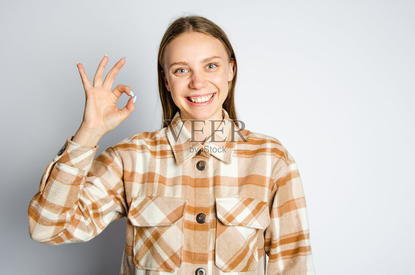 穿衬衫的女孩做了一个手势。概念都是写广告的好地方照片摄影图片