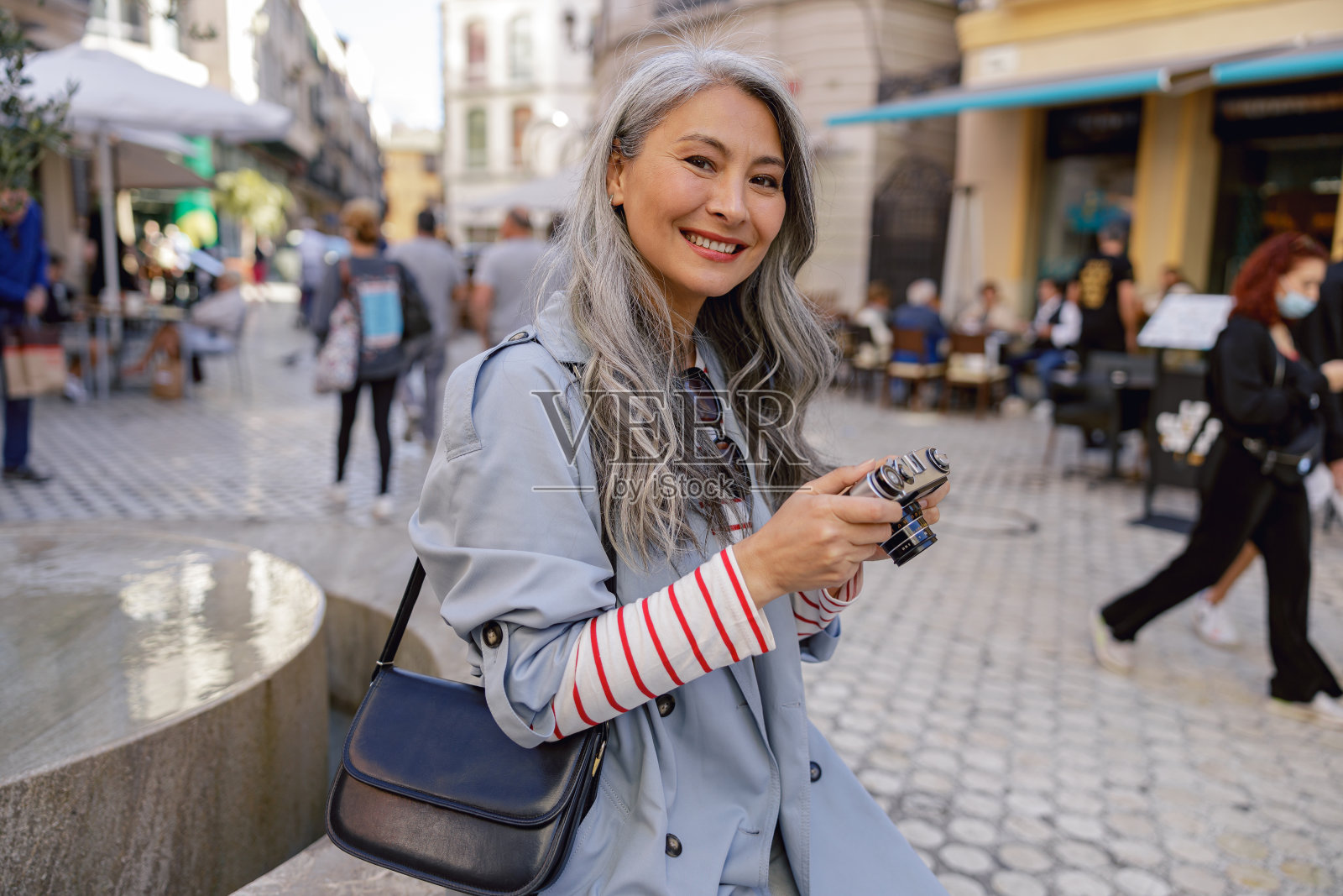 有吸引力的成熟女人与相机在城市街道照片摄影图片