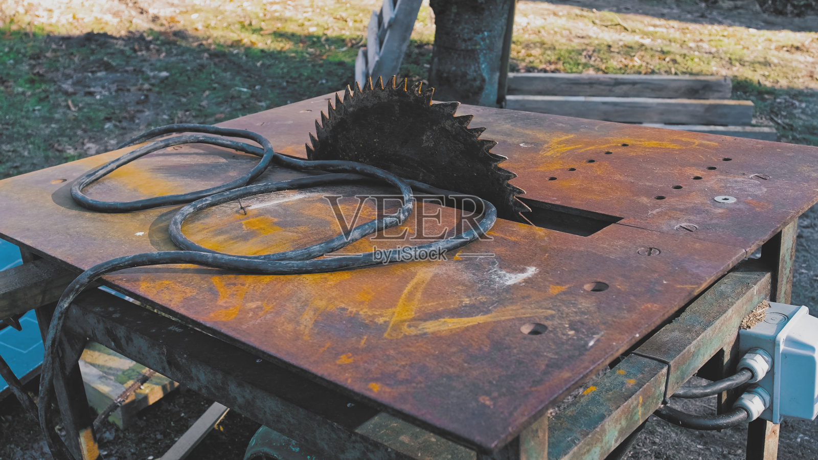 高功率电动发动机驱动的带生锈刀片和金属顶板的户外台锯照片摄影图片