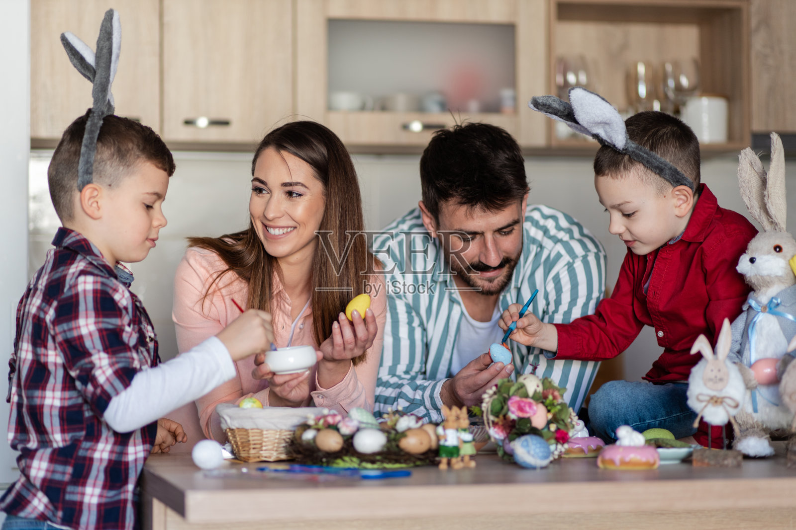 和父母一起装饰复活节彩蛋的男孩照片摄影图片