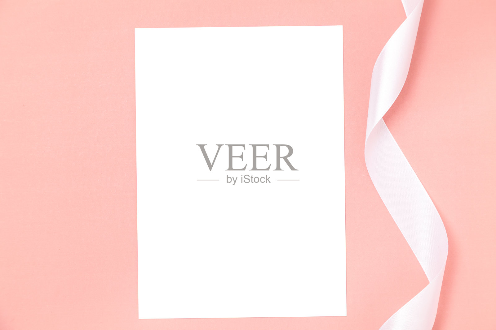 婚礼请柬或贺卡模型与白色缎带上的粉红色背景。照片摄影图片