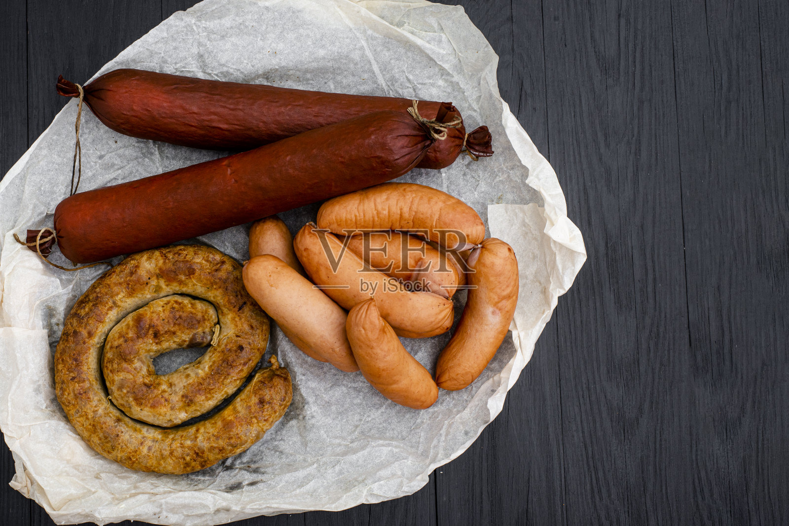 木制背景上不同类型的天然香肠。照片摄影图片
