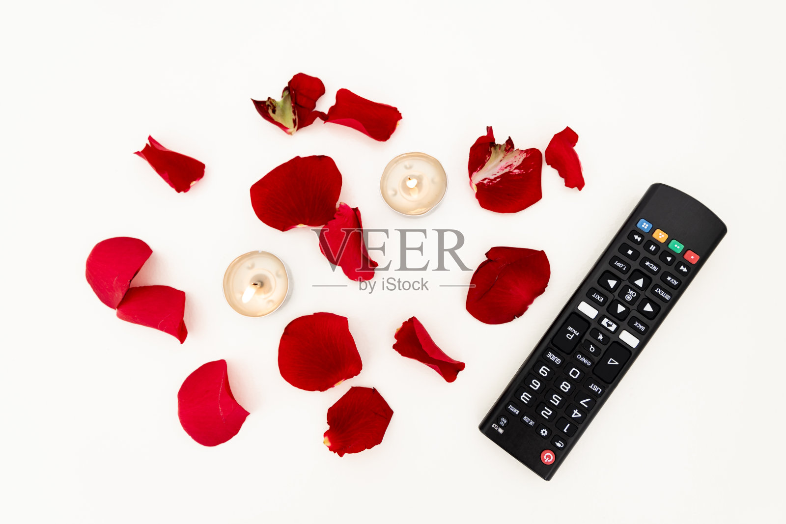 白色背景上的玫瑰花瓣和茶灯照片摄影图片