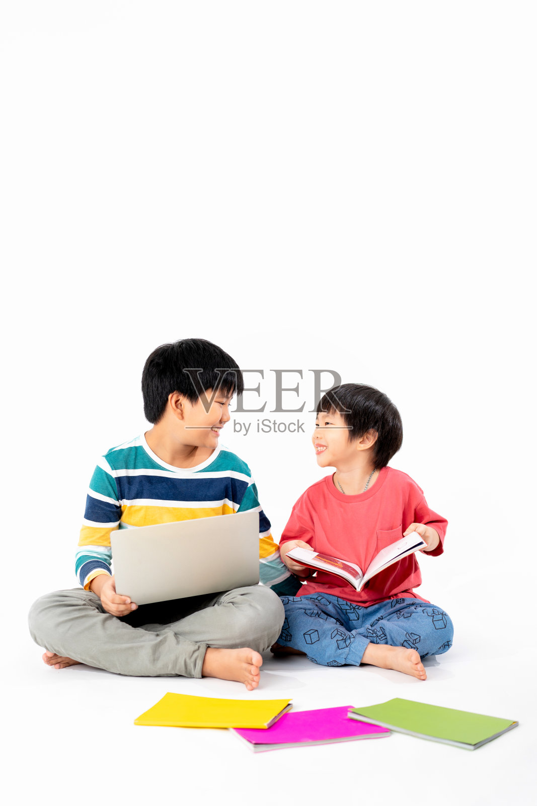 快乐亚洲男孩的肖像，兄弟在地板上笔记本电脑和书本孤立的白色背景，教育和学习的技术概念照片摄影图片