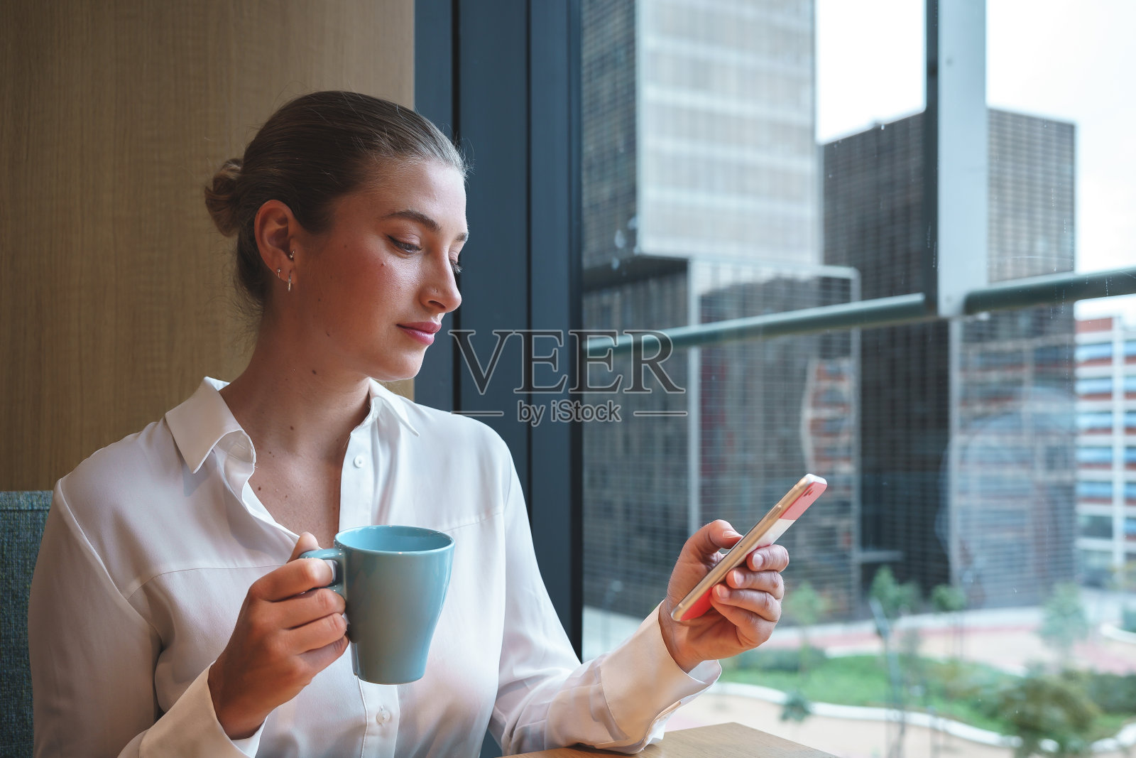 女商人在办公室浏览智能手机照片摄影图片