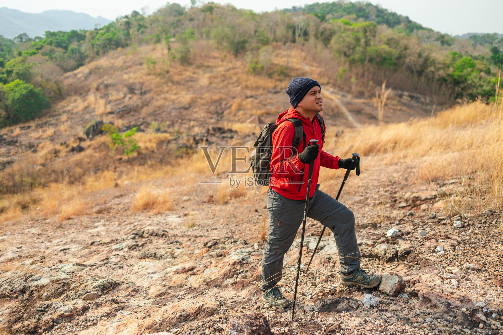 年轻的亚洲人登山穿夹克走在户外。游客在山顶徒步旅行。旅行探险远足概念。照片摄影图片