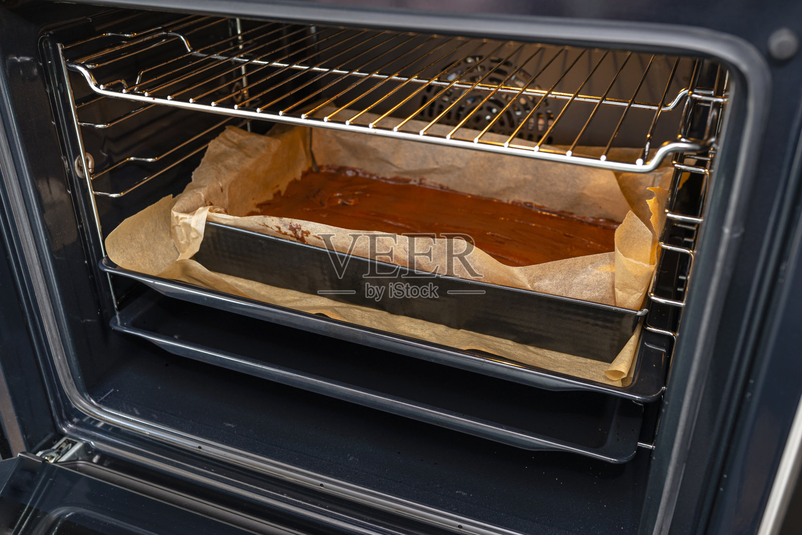 烤盘，将生面团放入烤箱，准备烘烤。照片摄影图片