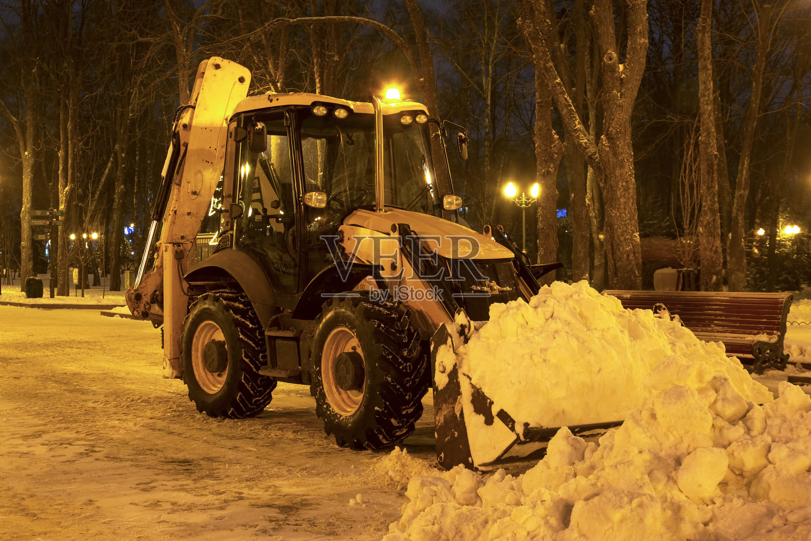 冬天晚上用拖拉机在公园里扫雪照片摄影图片