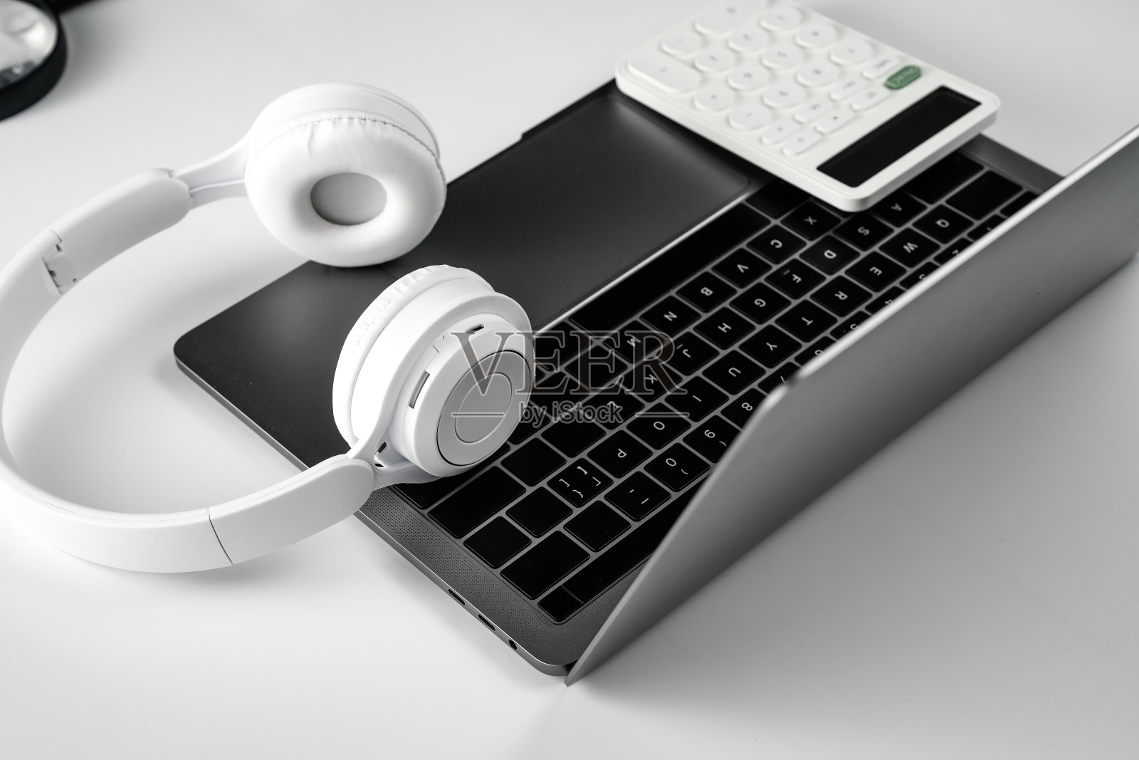 白色背景上的电脑，耳机和计算器照片摄影图片