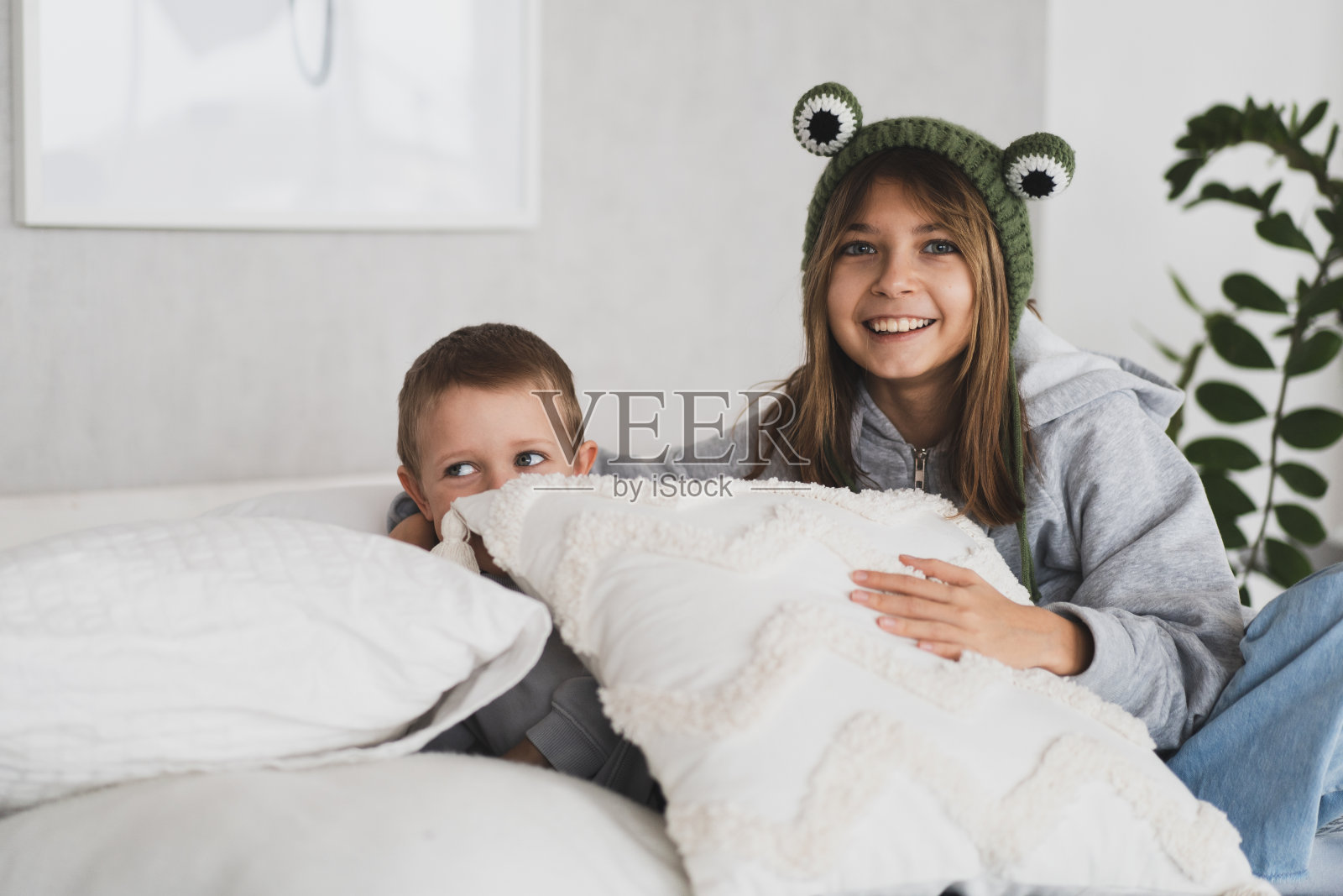 可爱的小兄妹在家里的床上玩得很开心，还有枕头大战照片摄影图片