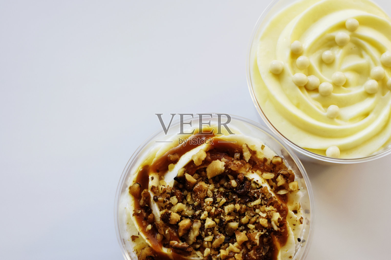 两种用海绵面团和蛋奶沙司做成的精致甜点。英国美食透明玻璃杯里的美味甜点。特写镜头。前视图。副本的空间。有选择性的重点。照片摄影图片