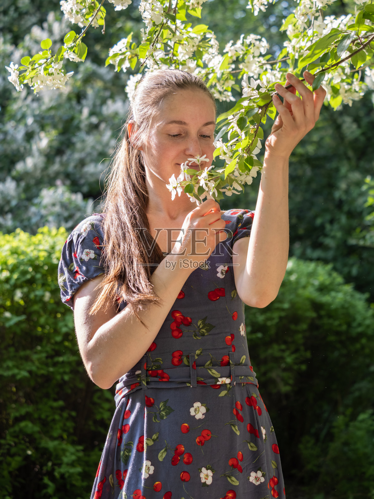 美丽的年轻女子没有化妆在春天公园的花树照片摄影图片