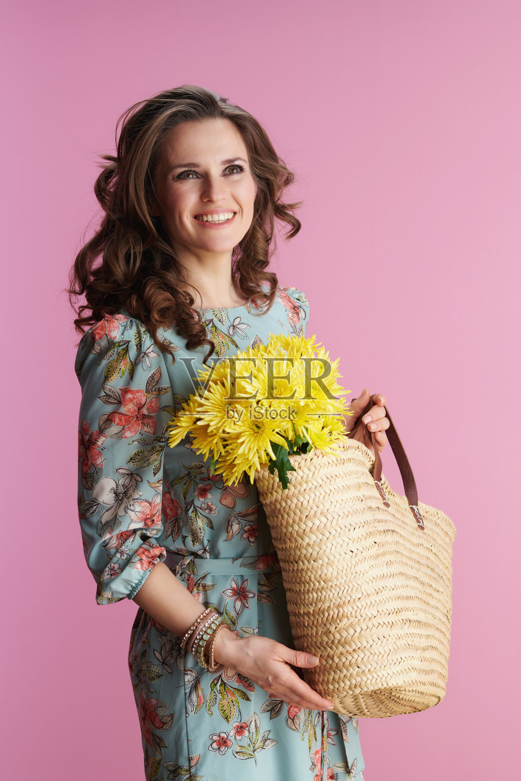 微笑的优雅的女人穿着粉红色的花裙子照片摄影图片