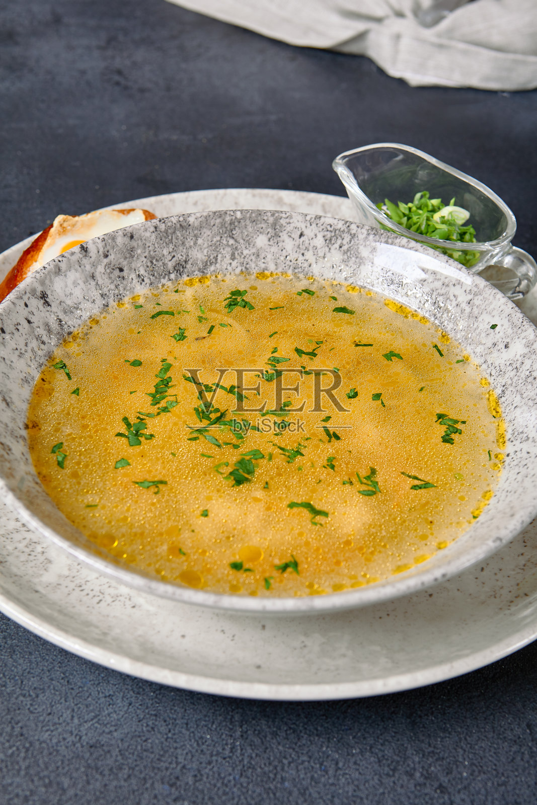 传统的碗食品-鸡肉面汤在黑暗的桌子上。汤在陶瓷碗上深色纹理背景与食品配料。照片摄影图片