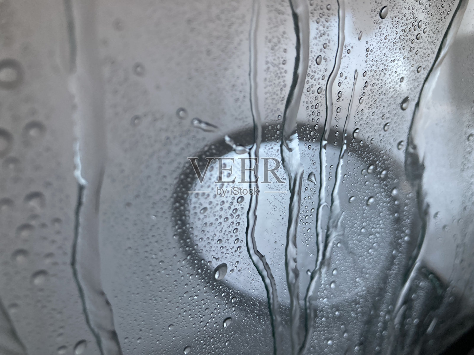 在洗车处，水沿着车窗流下来照片摄影图片