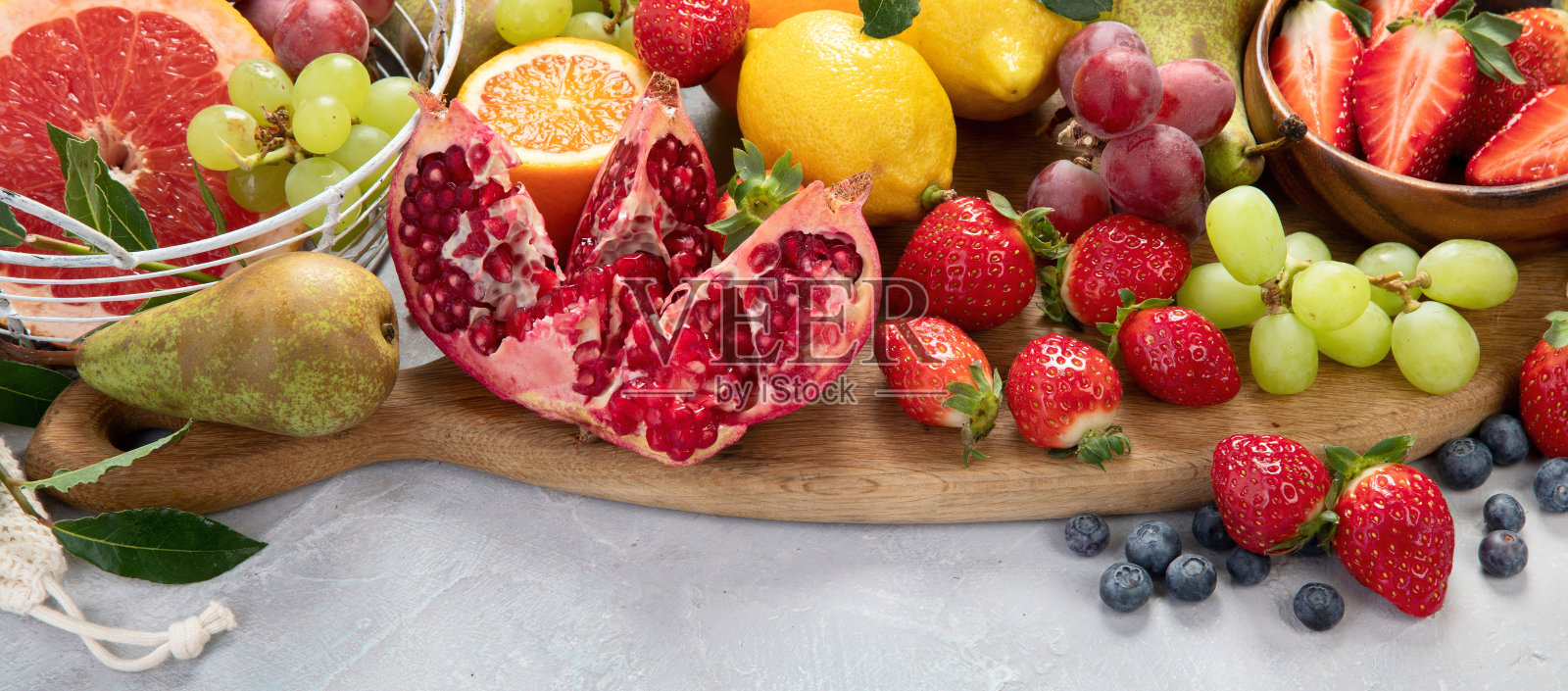 花色成熟的热带水果在浅灰色的背景。照片摄影图片