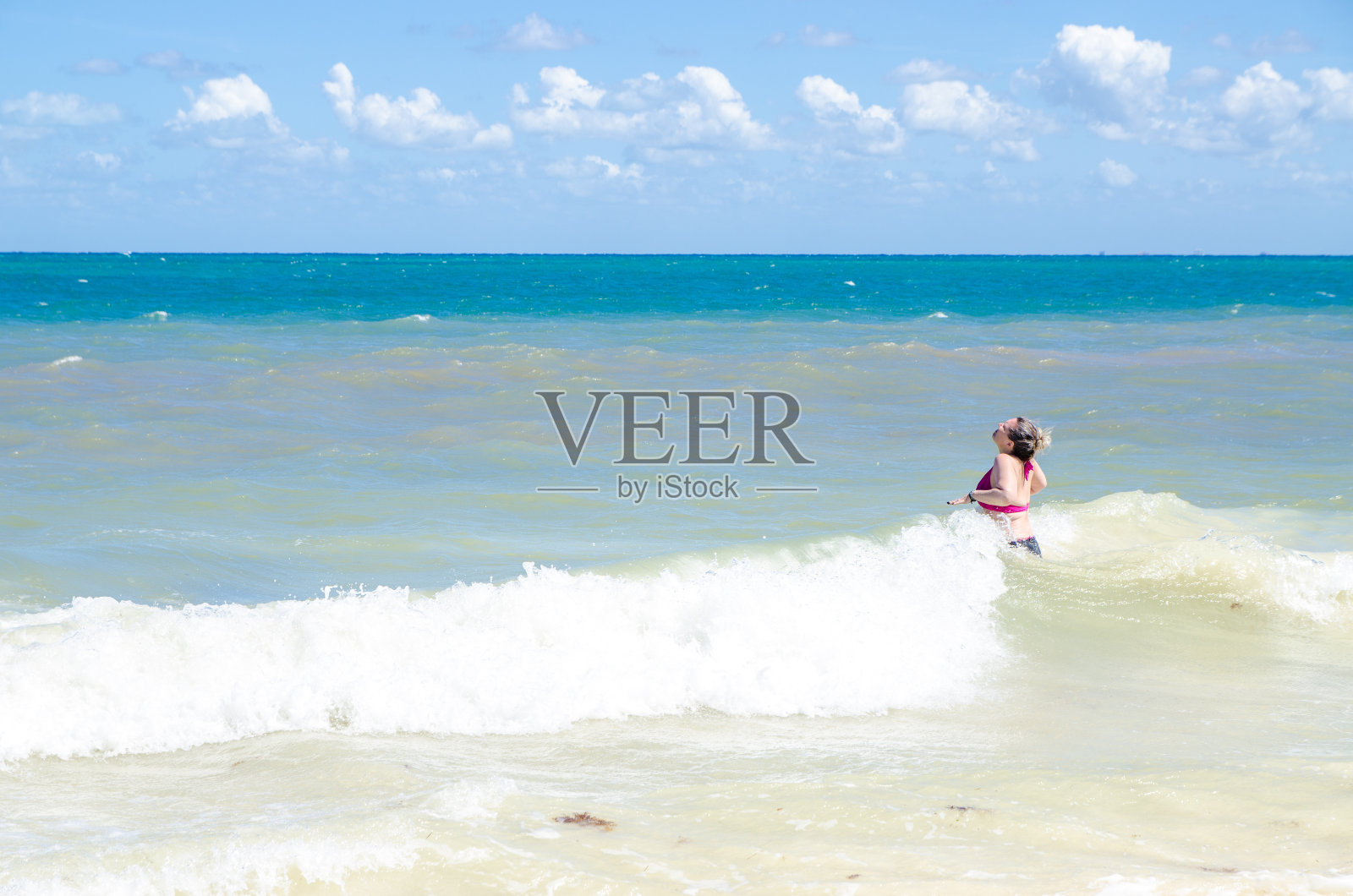 一名女子进入加勒比海水域照片摄影图片