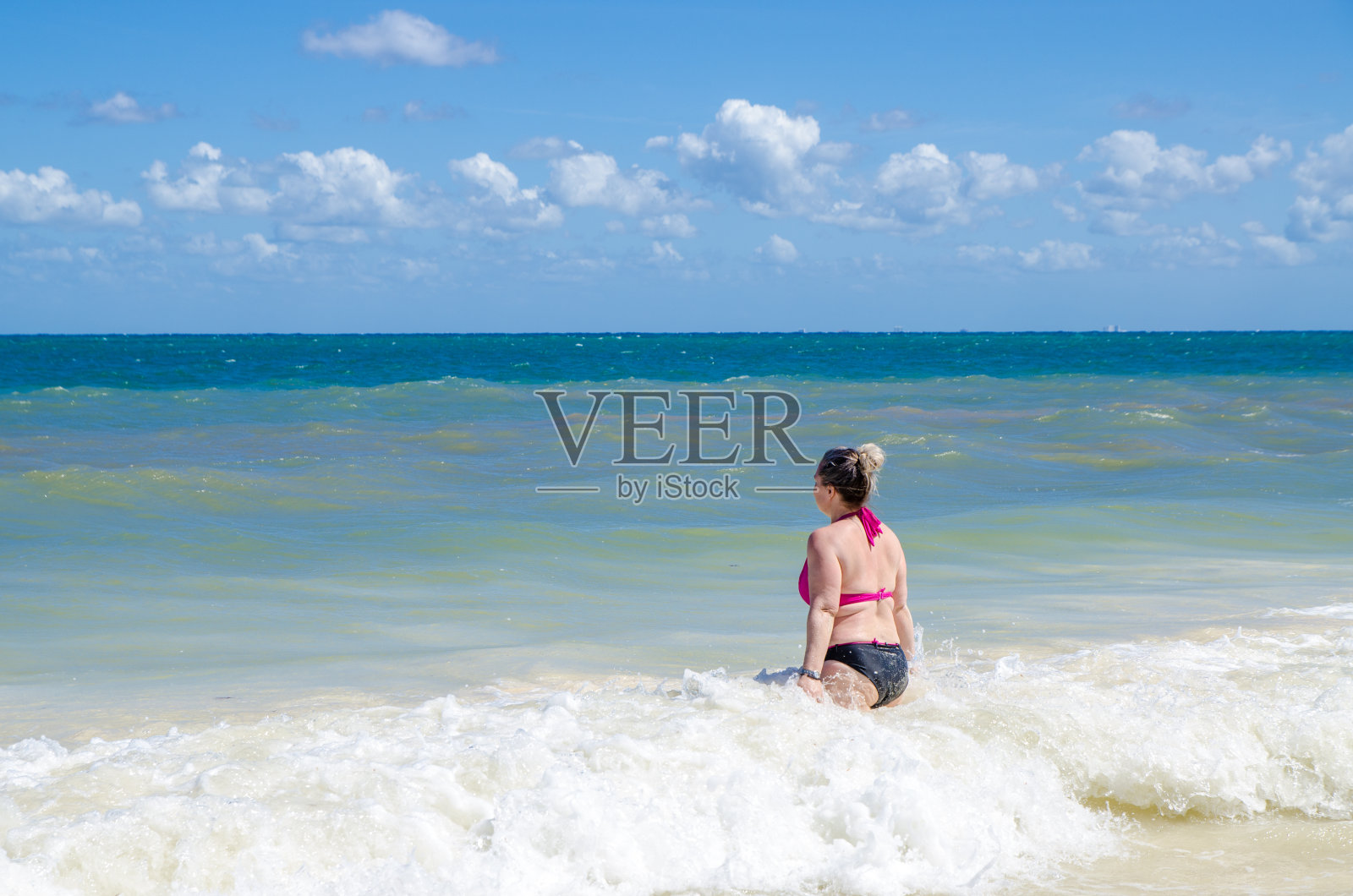 一名女子进入加勒比海水域照片摄影图片