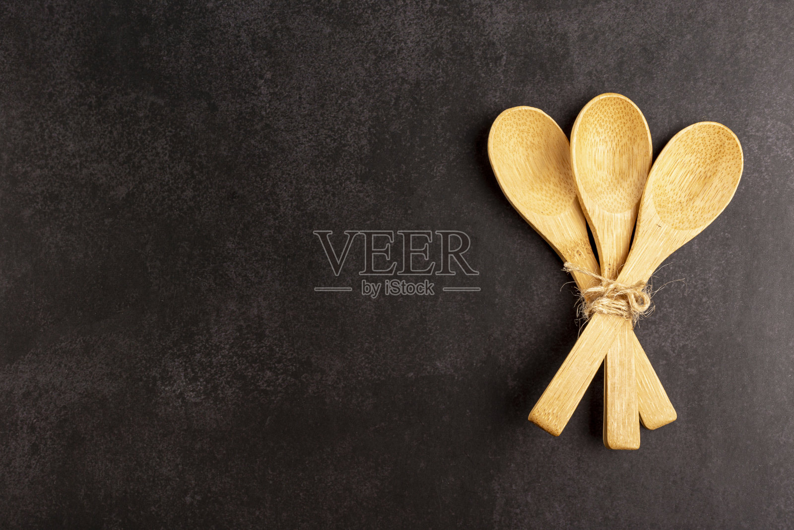 黑色背景上的木制餐具。照片摄影图片