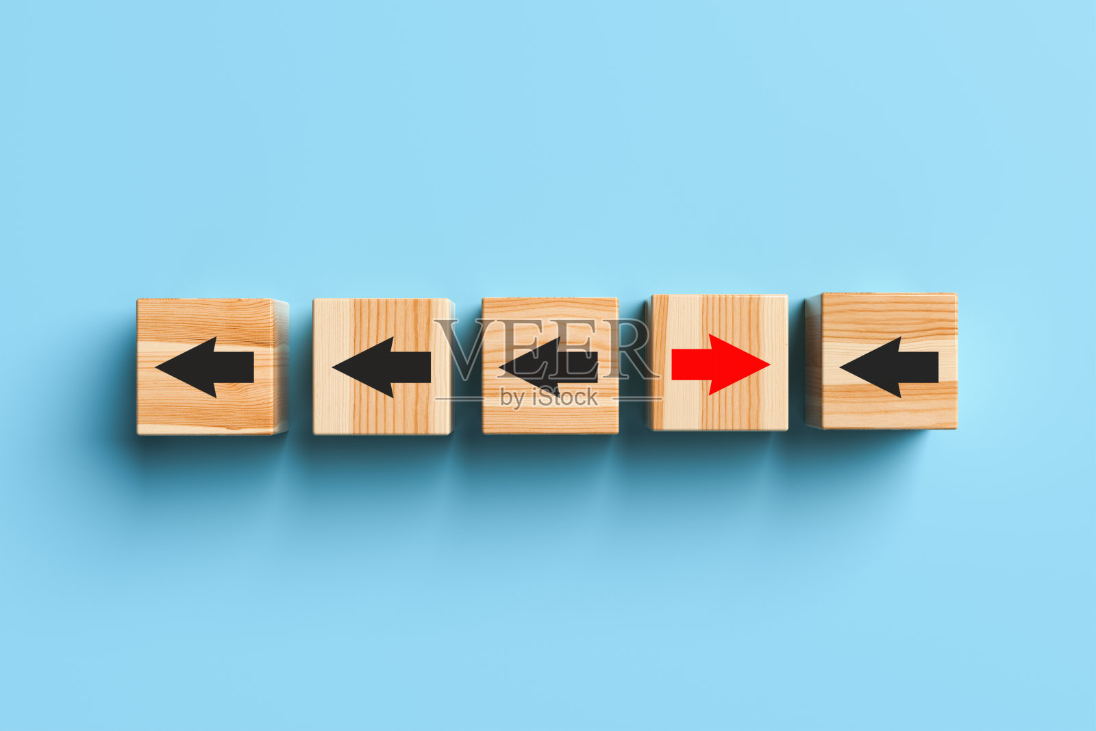 带箭头的木块在蓝色背景下从人群中脱颖而出，向前移动。照片摄影图片