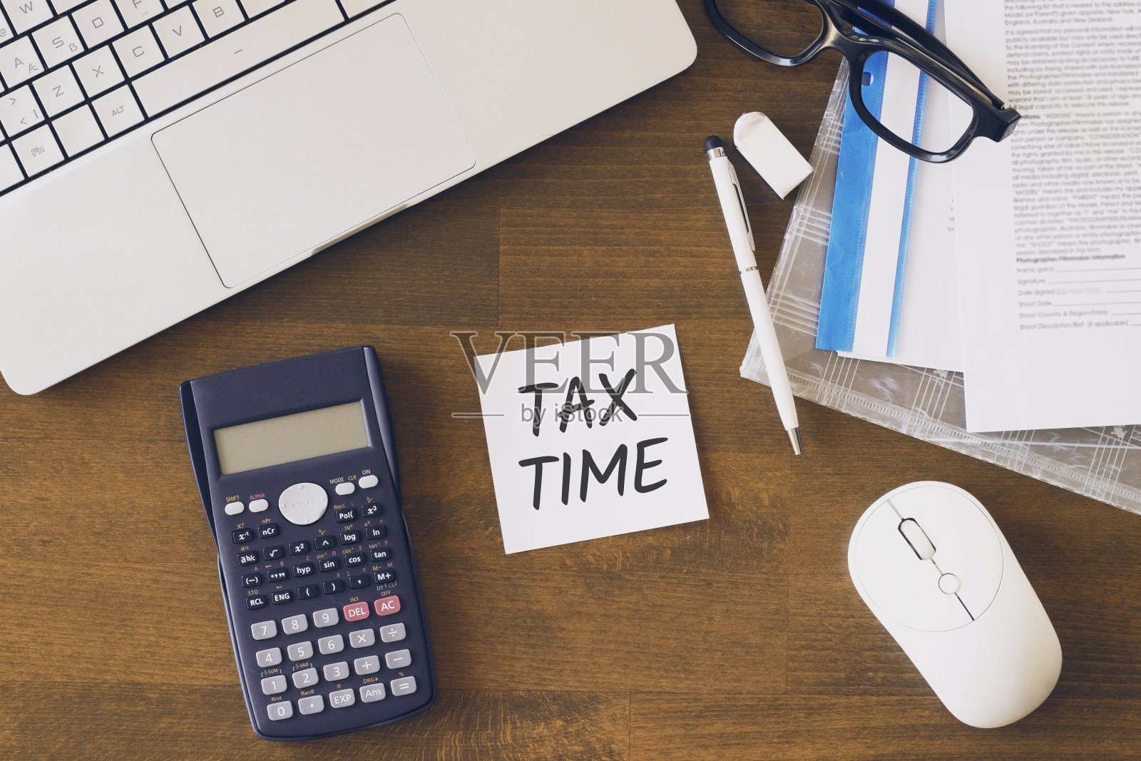 在办公桌上手持税单，电脑和文件。税务及经营理念。俯视图照片摄影图片