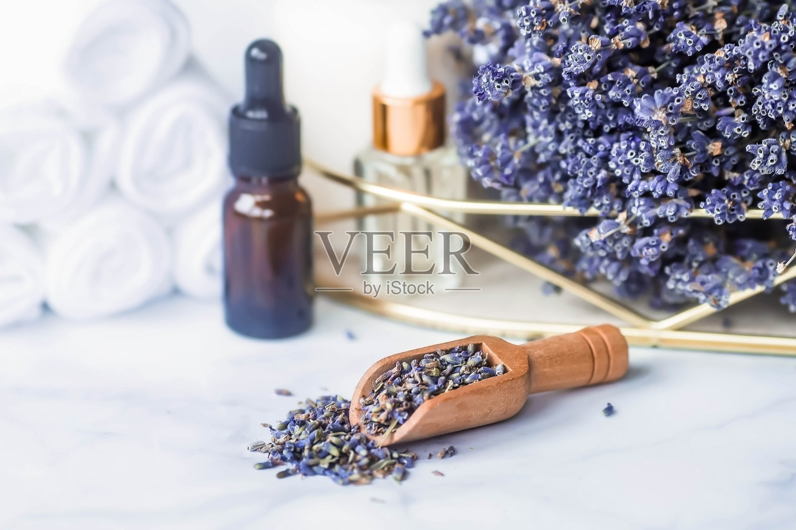 天然薰衣草草。薰衣草油瓶，蜡烛和白色毛巾在白色大理石的背景上。铭文的地方。美丽健康理念。照片摄影图片