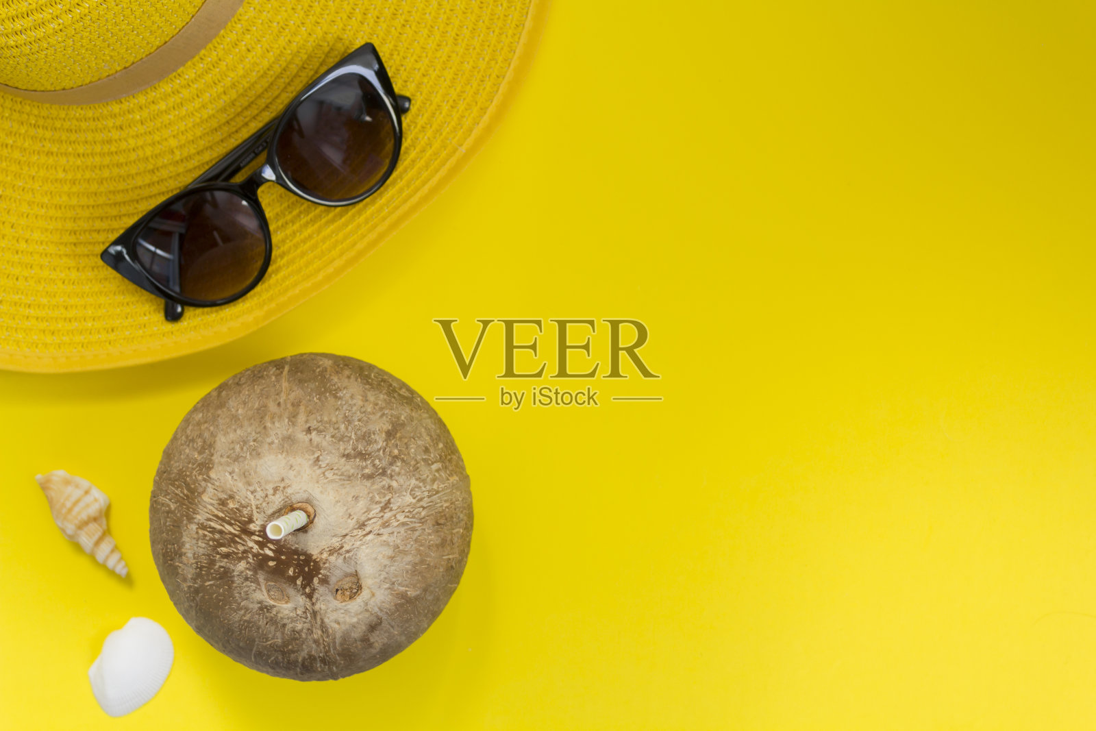 草帽，太阳镜和黄色背景的草编椰子。顶部视图与复制空间照片摄影图片