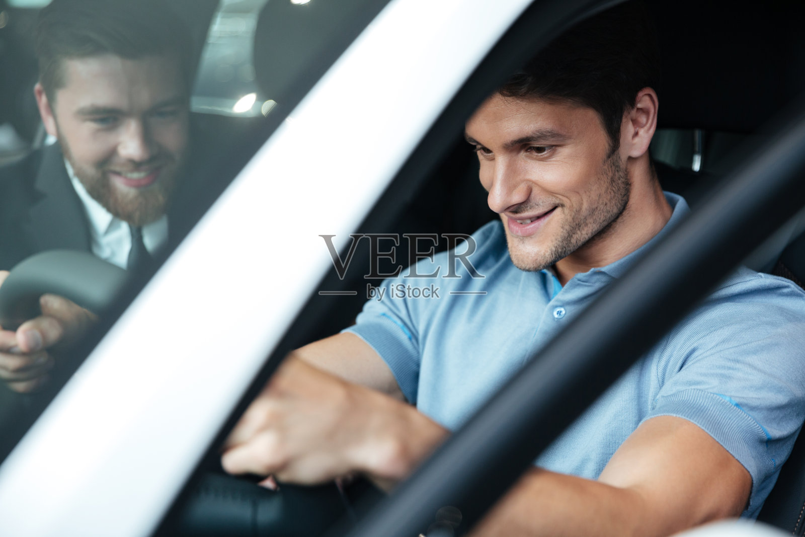 一对微笑的年轻夫妇坐在车内测试一辆新车照片摄影图片