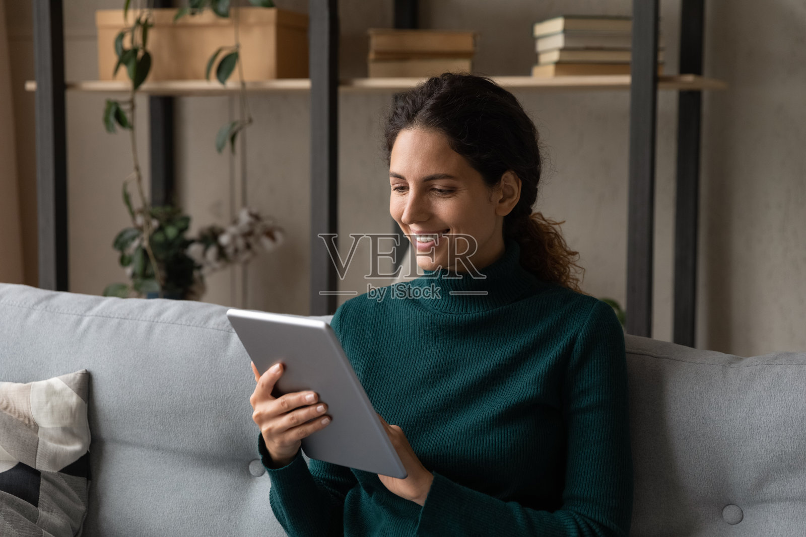 微笑的西班牙妇女在网上使用平板电脑购物照片摄影图片