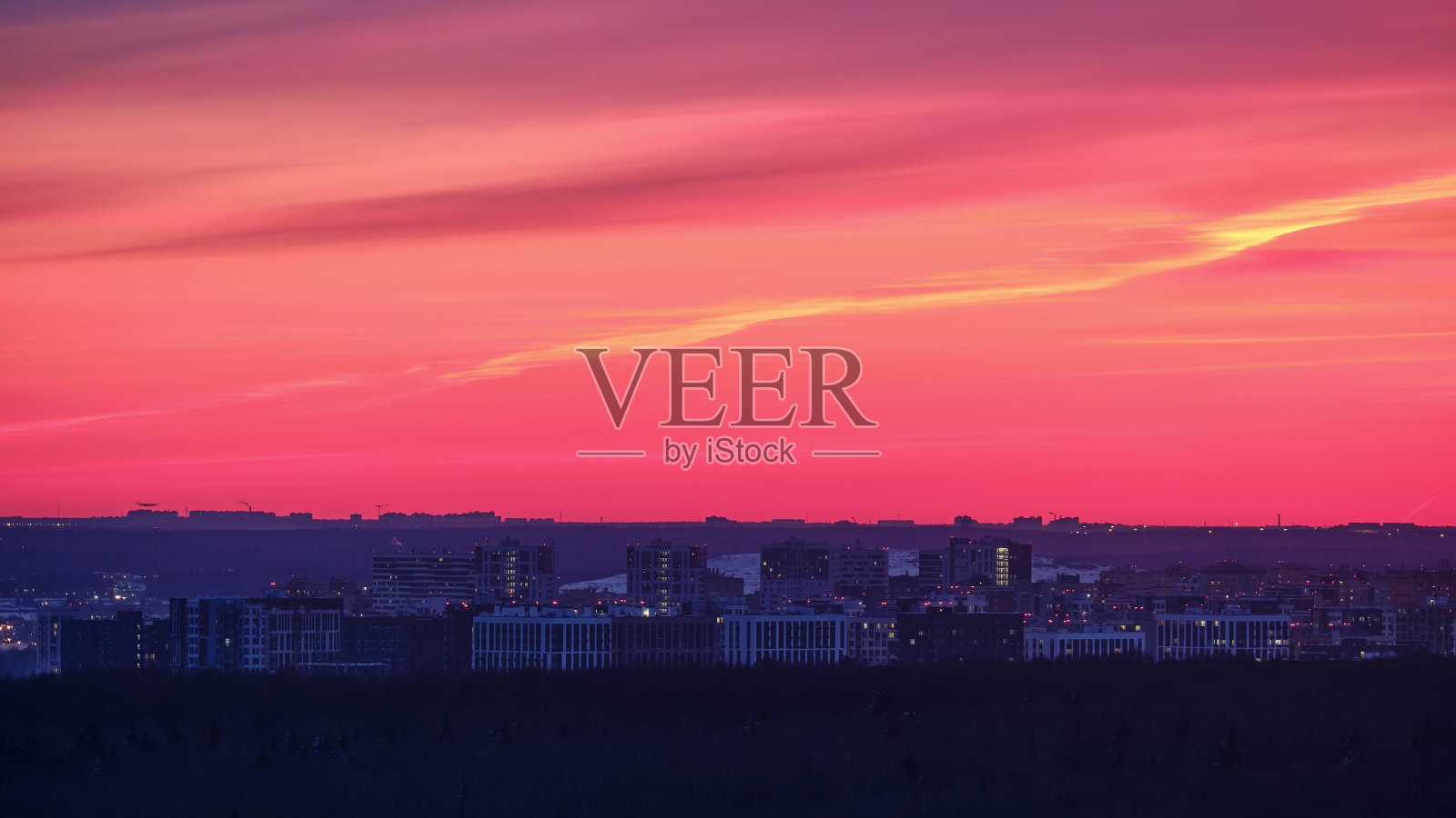 夜晚的城市景观，城市住宅的灯光开始亮起，时间流逝。多层建筑后，夕阳西下，晚霞满天，时间流逝照片摄影图片