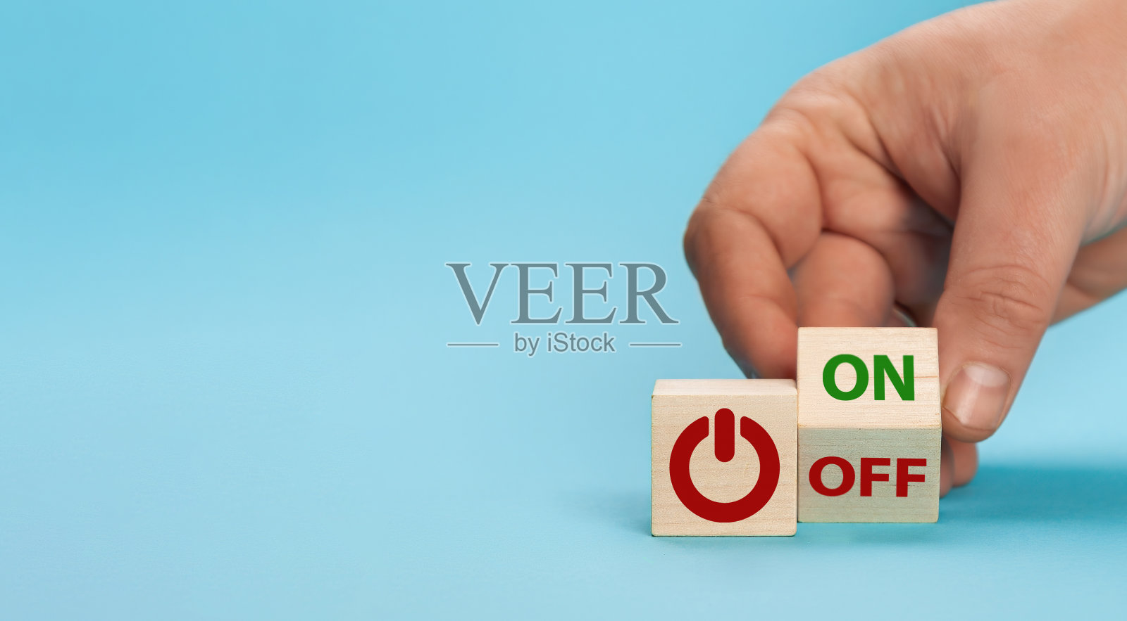 手掷骰子，将单词“off”改为“on”。在一个木制立方体上的开关按钮，在蓝色背景上刻有文字。起停按钮。照片摄影图片