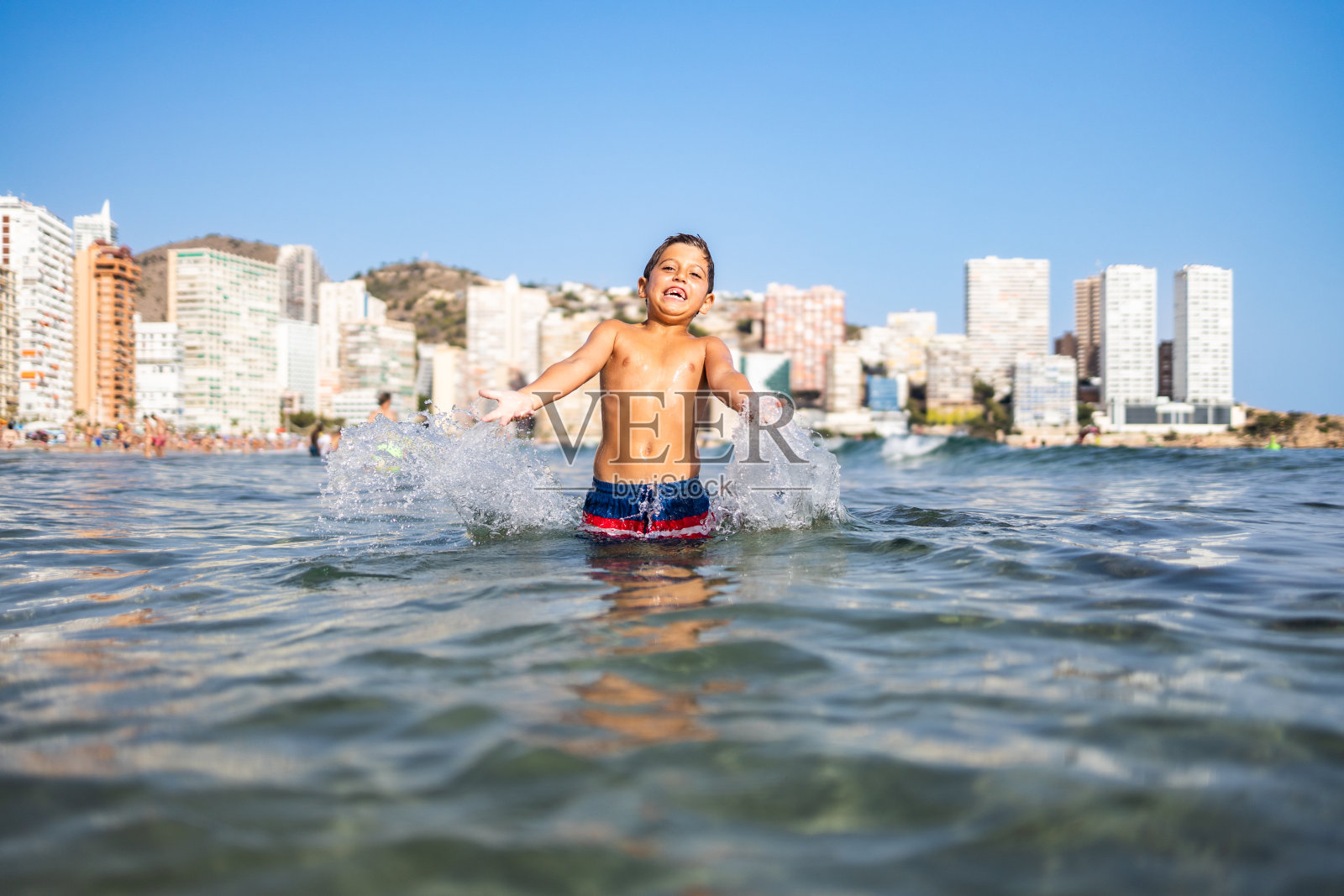 有趣的孩子在城市海滩上泼水照片摄影图片