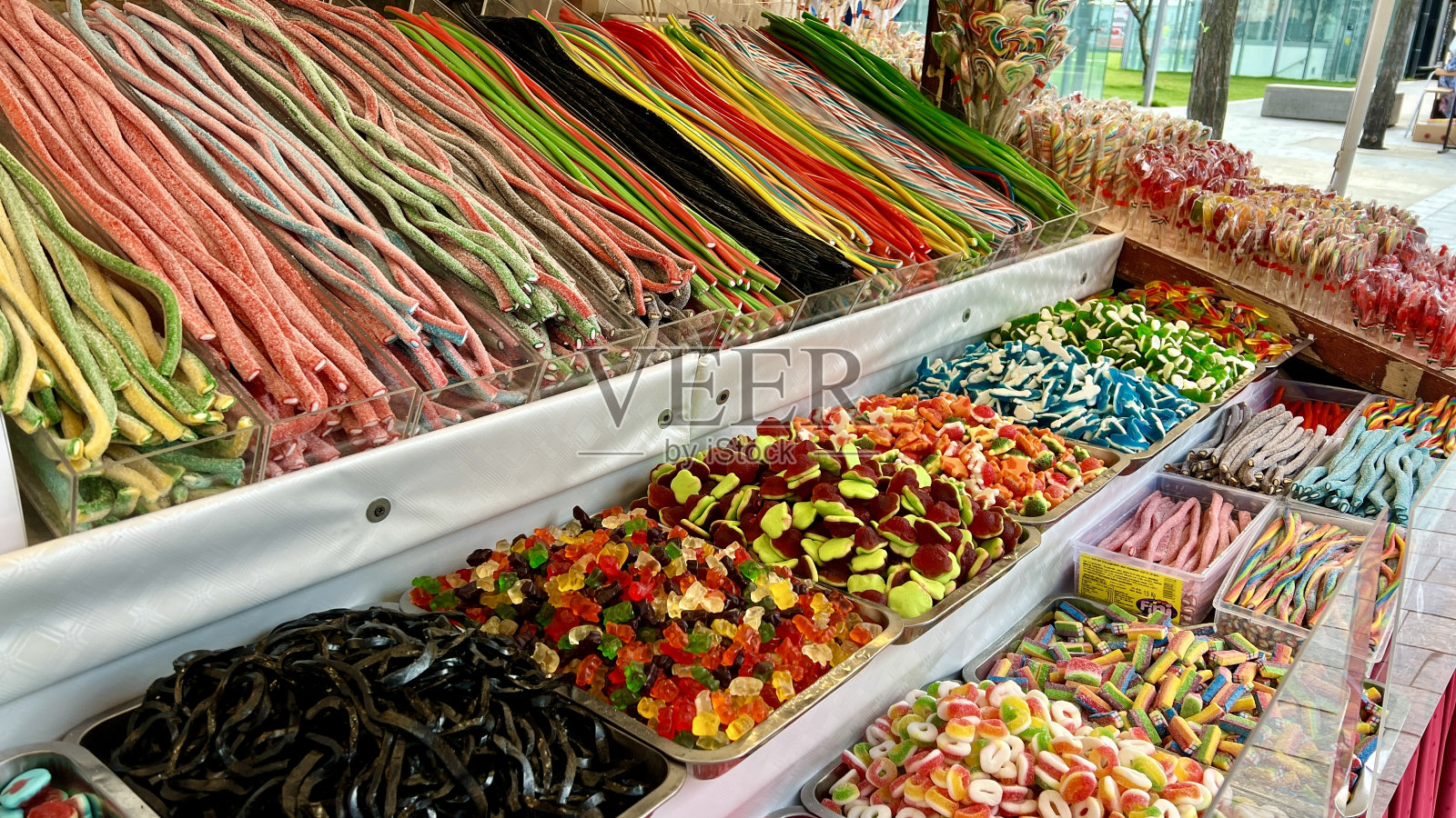 柜台上摆放着各种各样的糖果，五颜六色，就像唾液从果冻雕像流到意大利面和巧克力一样照片摄影图片